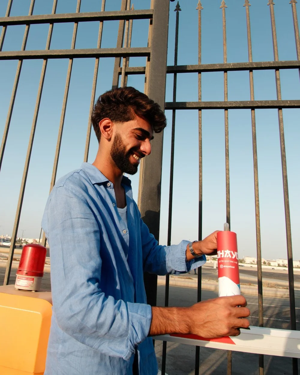 Man in a linen shirt opening an Ohayo on a rooftop