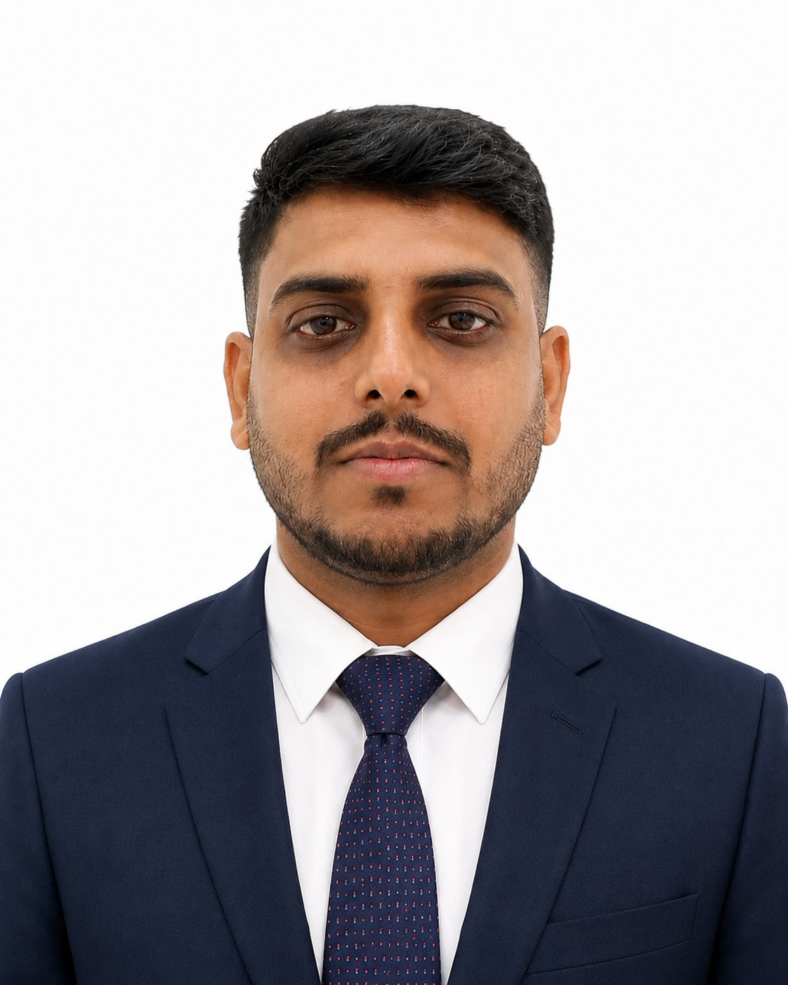 Headshot of a young man in a navy blue suit, white shirt, and navy blue tie with red dots, against a white background.