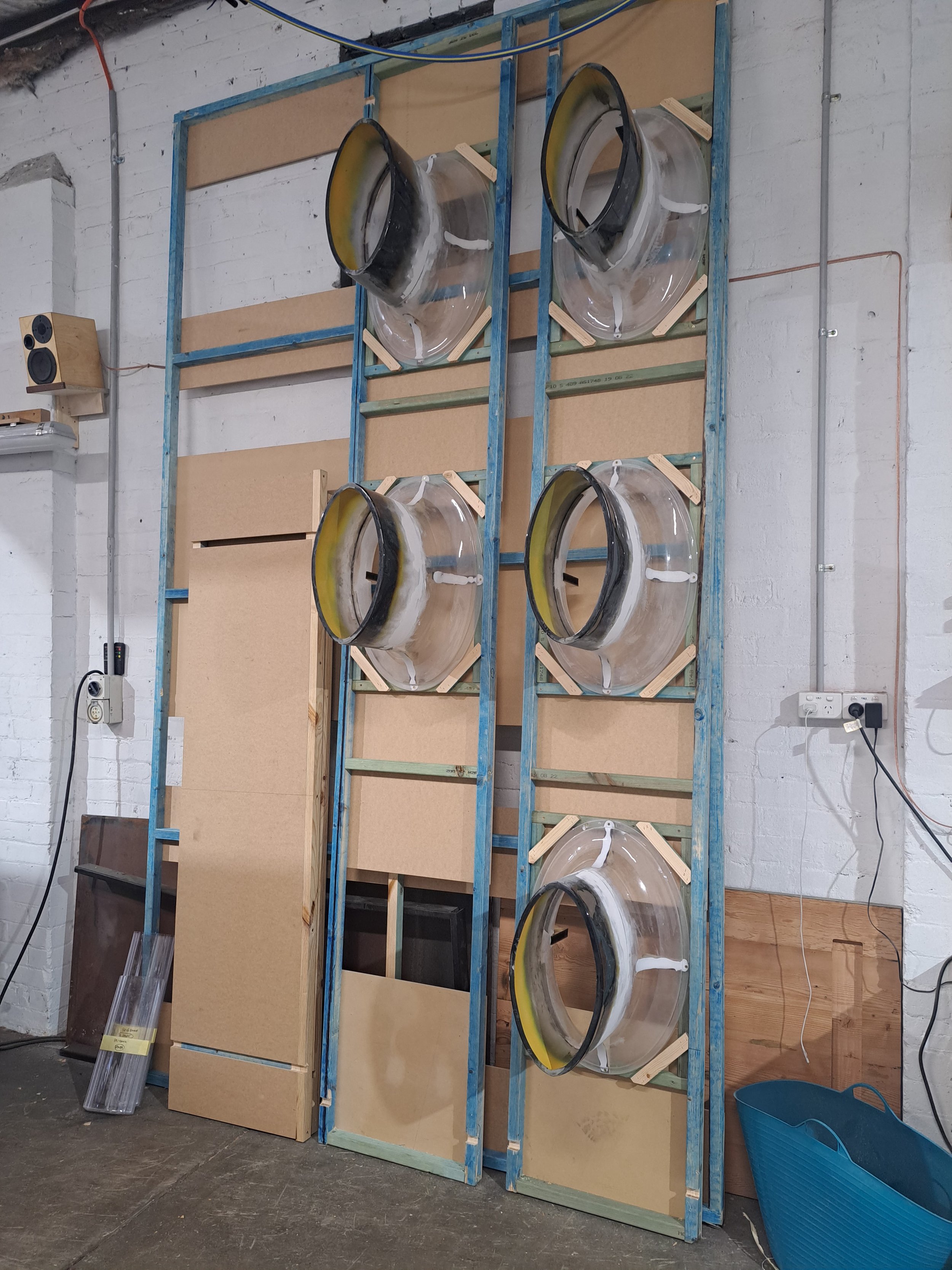 Custom built props, spray booth for cylindrical structures and a large white curved structure mounted on concrete bases. Custom high end luxury retail brands window dressing, installation. HR Productions Sydney