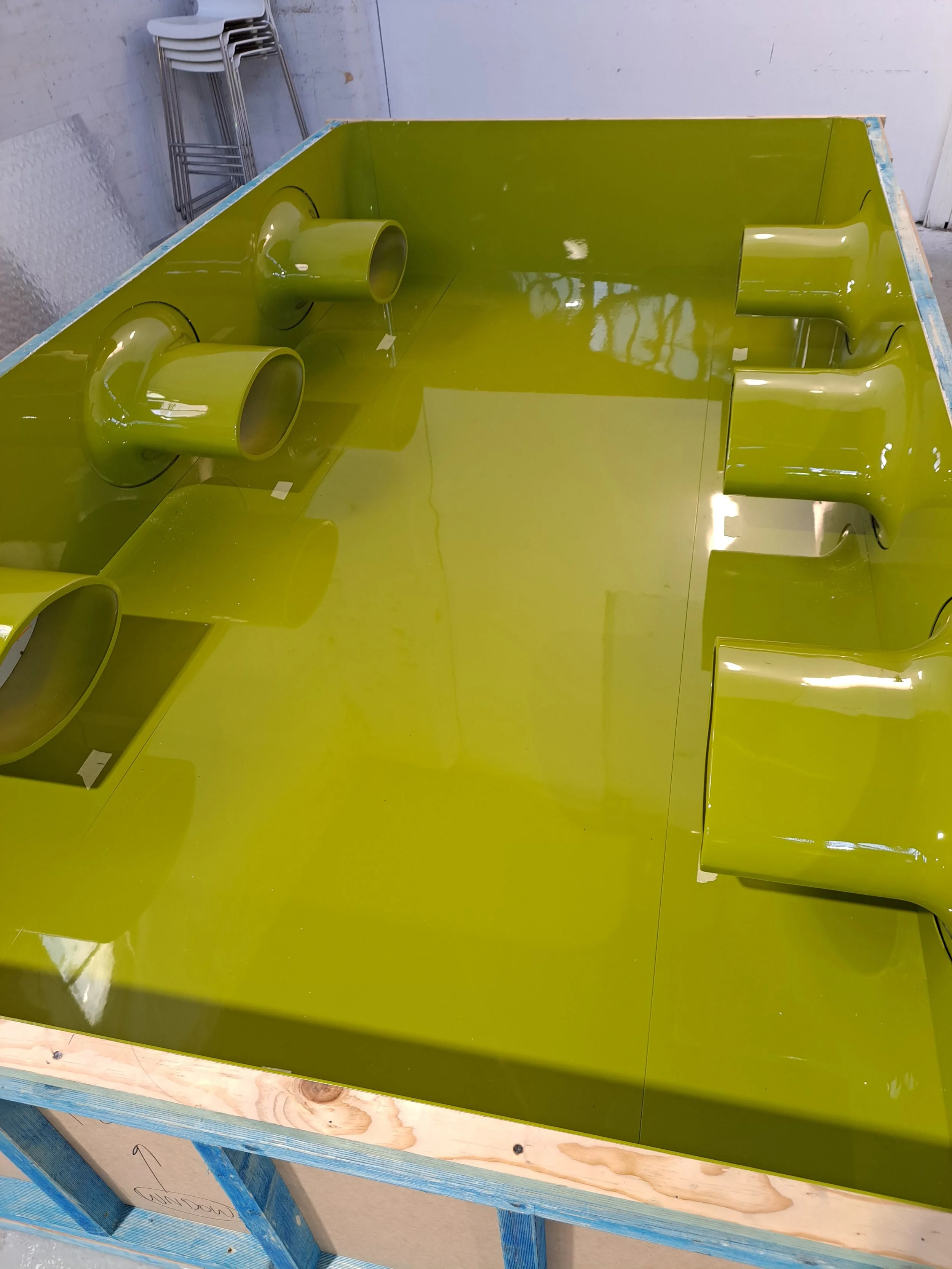 A lime green fiberglass panel. Custom built props, spray booth for cylindrical structures and a large white curved structure mounted on moulded bases. Custom high end luxury retail brands window dressing, installation. HR Productions Sydney