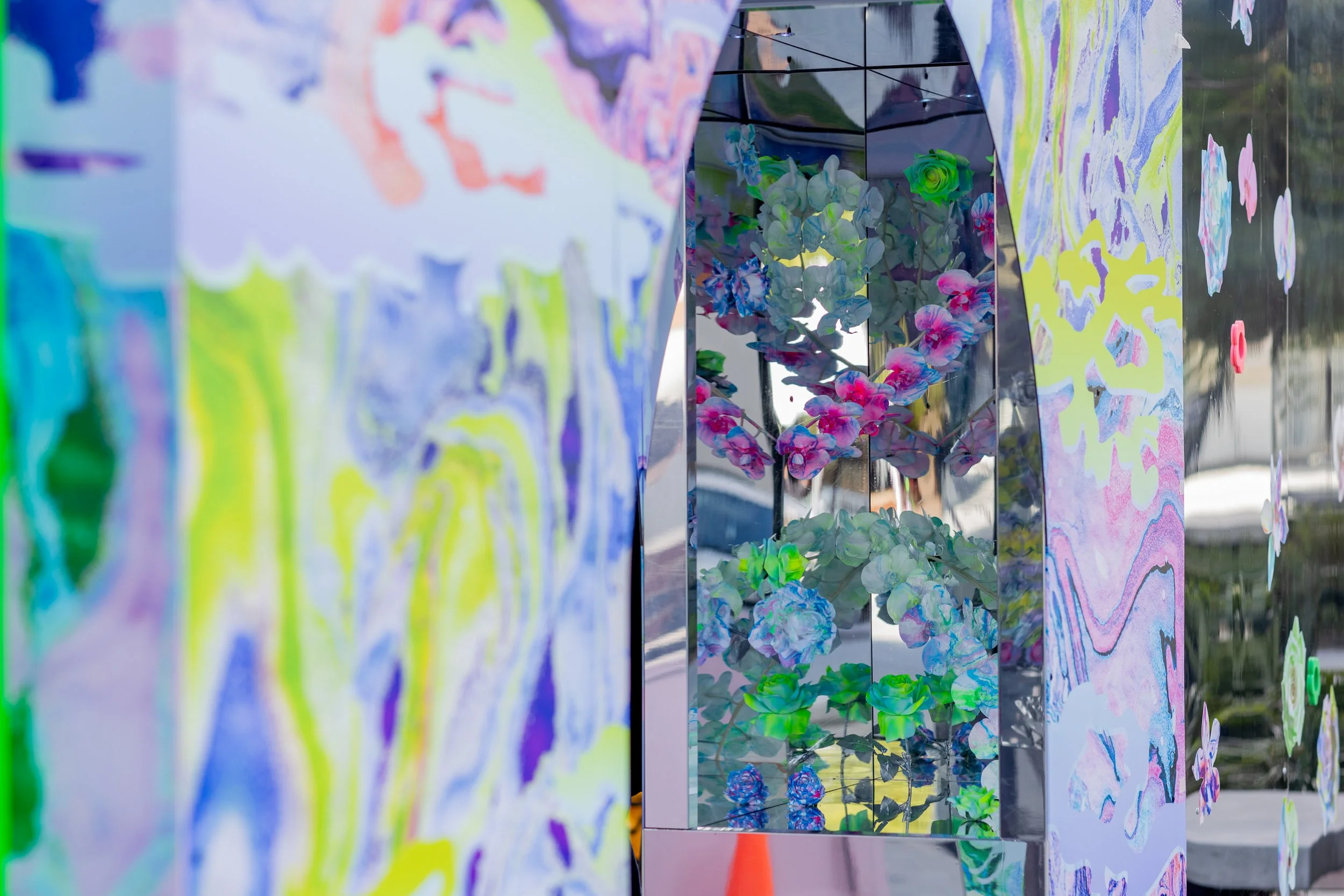 HR Productions Custom built artist collaboration. ACID FLWRS Perth outdoor installaton. neon colours. Colorful dipped florals on marbled display stand in an outdoor setting, mirrored chrome large stand