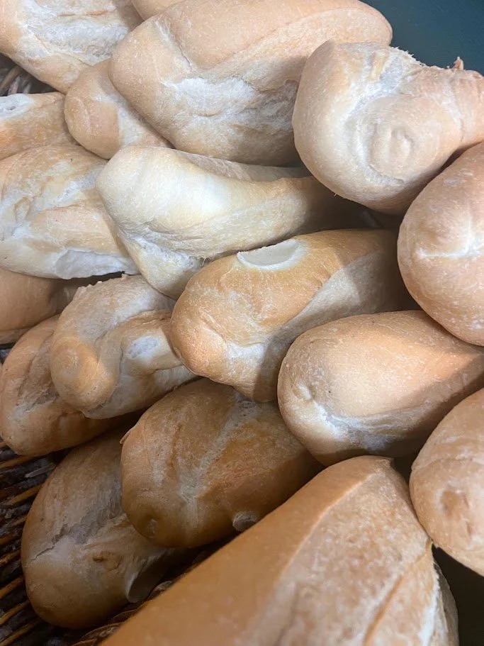 Close‑up of bread rolls piled together with a light dusting of flour from a Liverpool bakery