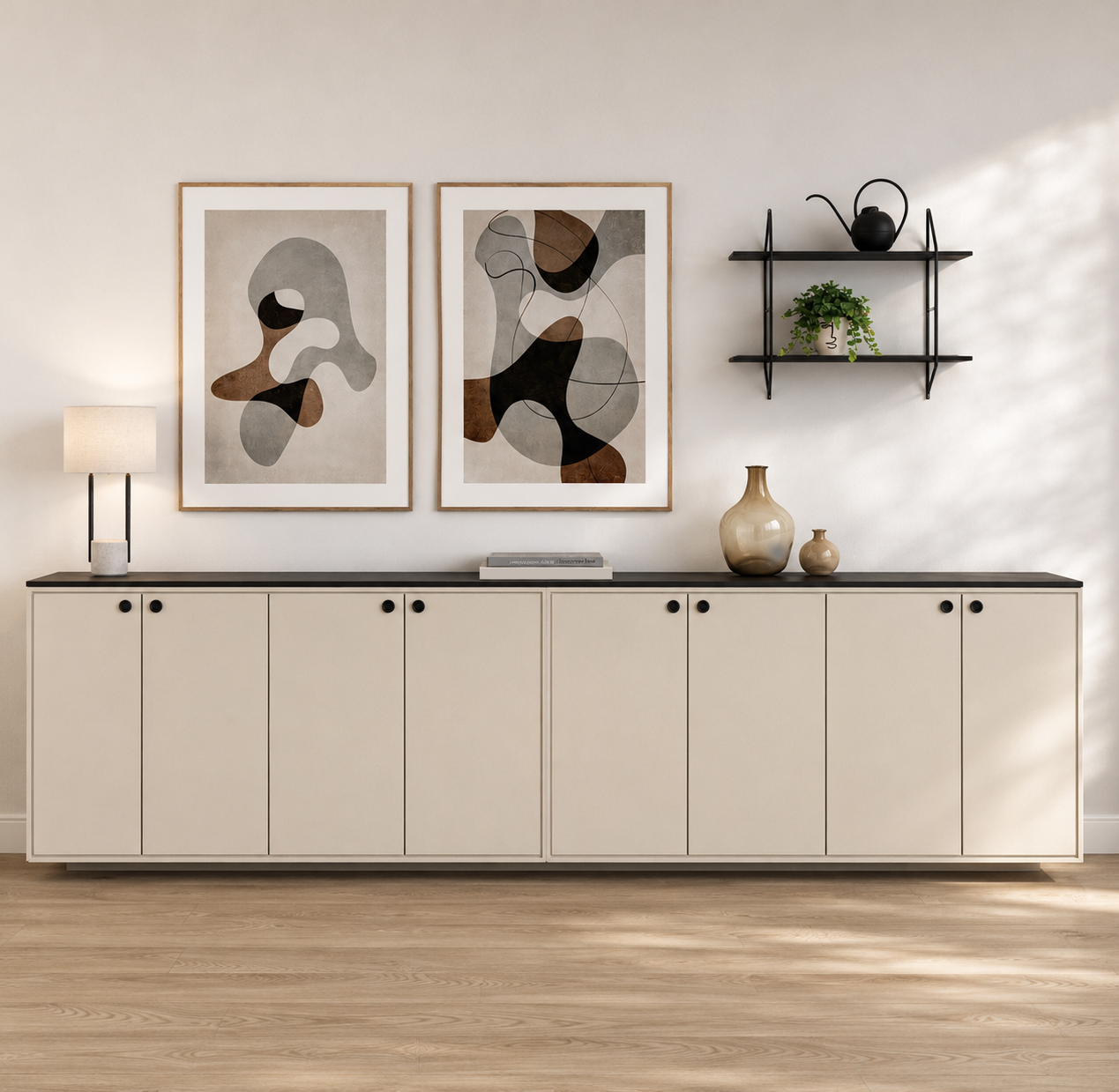Modern interior with a white sideboard, two abstract art pieces, decorative vases, a wall shelf with a potted plant and a black teapot, and a table lamp, all against a white wall.