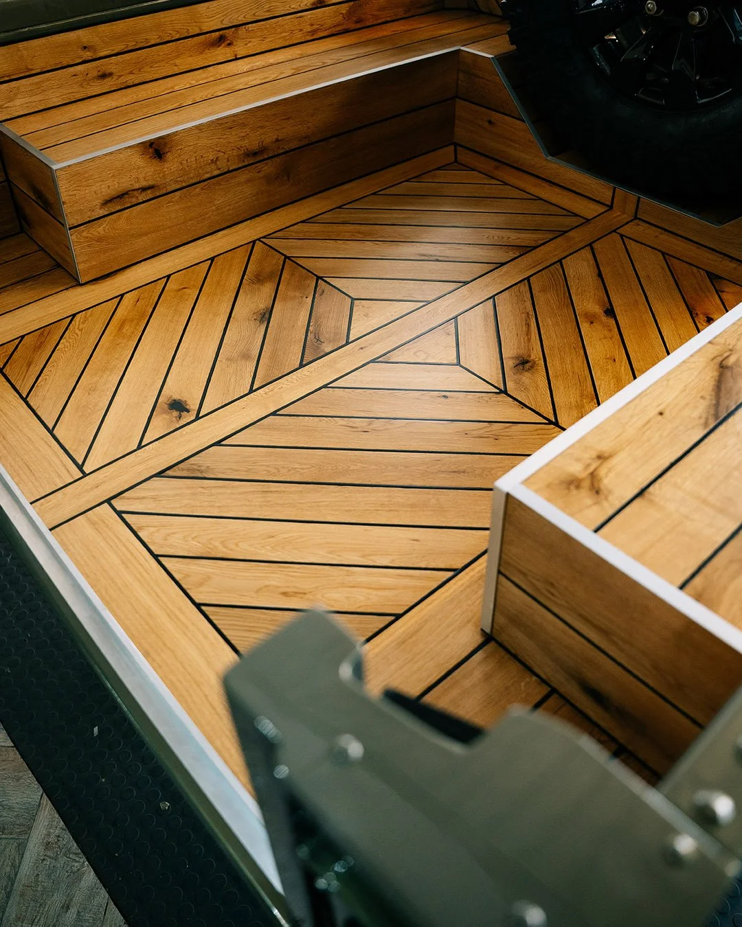 Close-up of a wooden jukebox floor with a geometric pattern, surrounded by matching wooden seating.