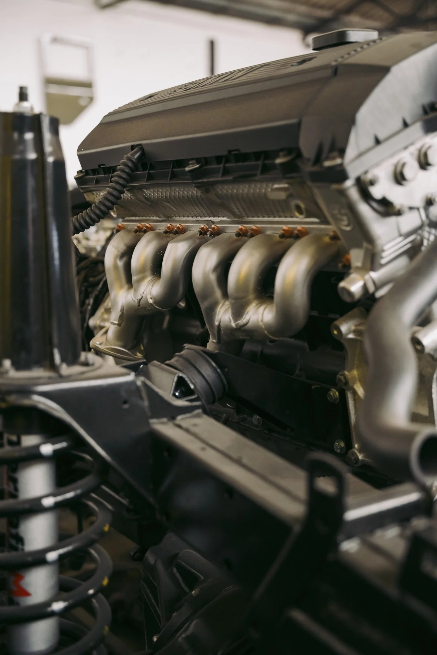 Close-up of a race car engine with metallic pipes and components.