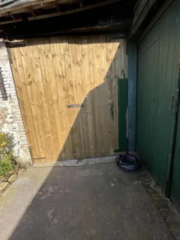 Porte de garage en bois neuve posée par DLM Services Lorenzo Delorme, artisan rénovation à Château-Gontier-sur-Mayenne, Mayenne