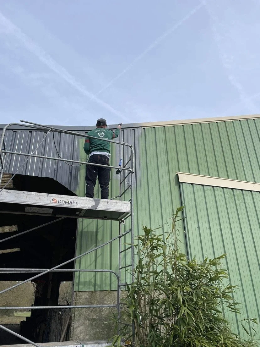 Peintre de DLM Services (Lorenzo Delorme) rénovant un bardage métallique vert à Craon, Mayenne
