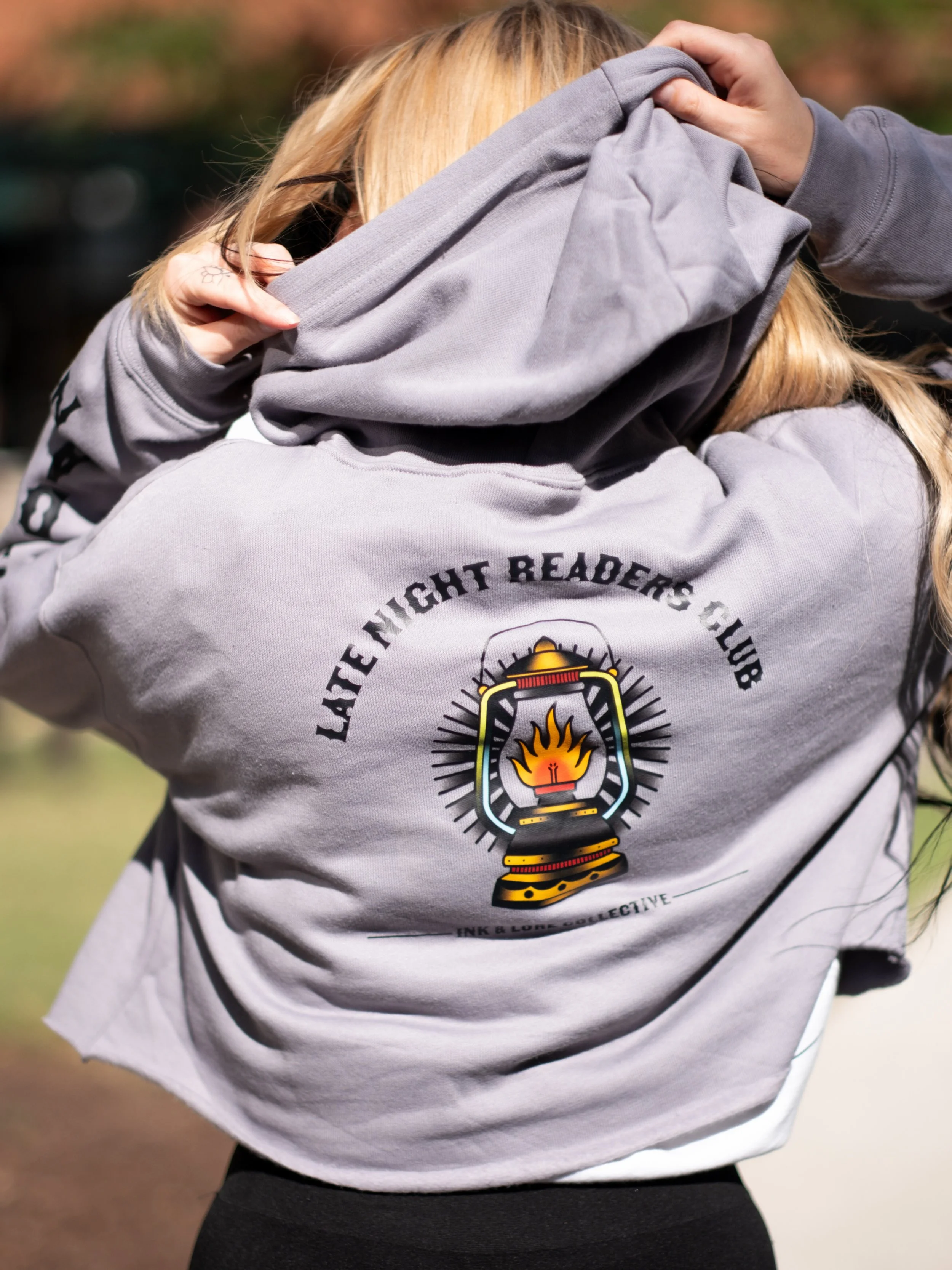 Can we all agree the Late Night Readers Club has the best dress code? 👀📖🔥

Our cropped hoodie is officially OUT NOW&mdash;featuring our lantern flash on the back, Ink &amp; Lore logo on the front, and &ldquo;After Dark//Until Dawn&rdquo; down the 