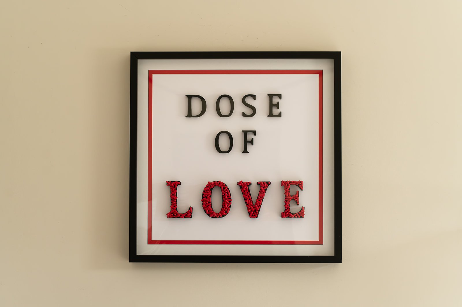 Dose of Love by Julie Langford, framed contemporary artwork created from red pharmaceutical capsules.