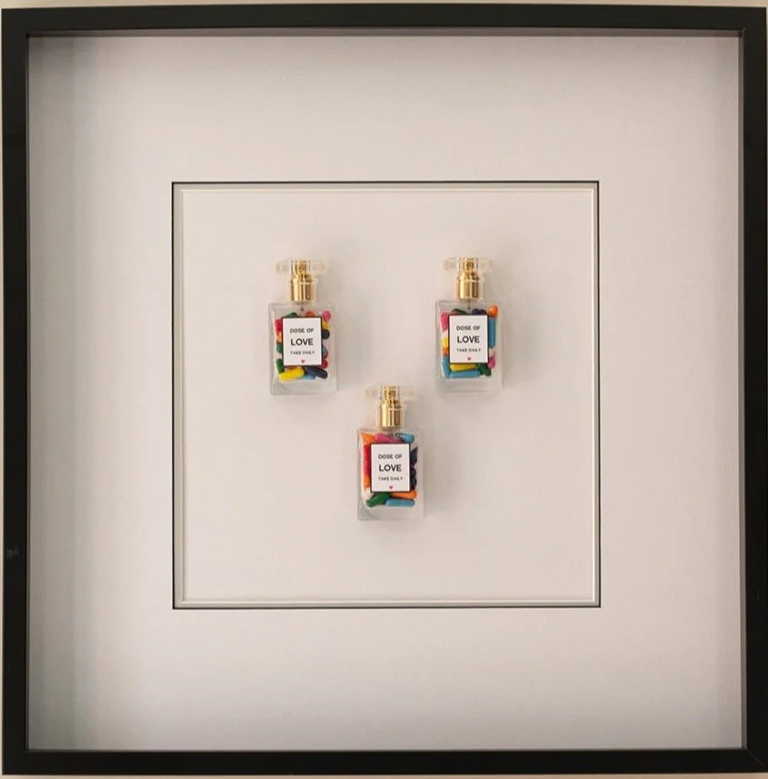 Three perfume bottles labeled 'Dose of Love' with colorful candies inside, arranged in a triangle on a white background.