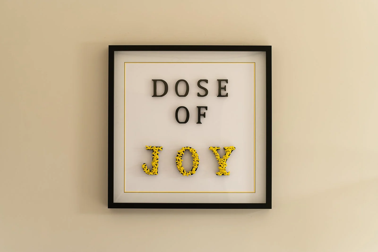 Dose of Joy by Julie Langford, framed contemporary artwork created from yellow pharmaceutical capsules.