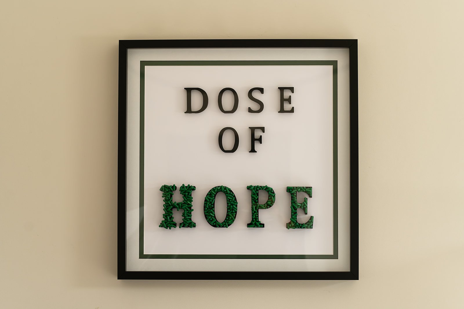Dose of Hope by Julie Langford, framed contemporary artwork created from green pharmaceutical capsules.