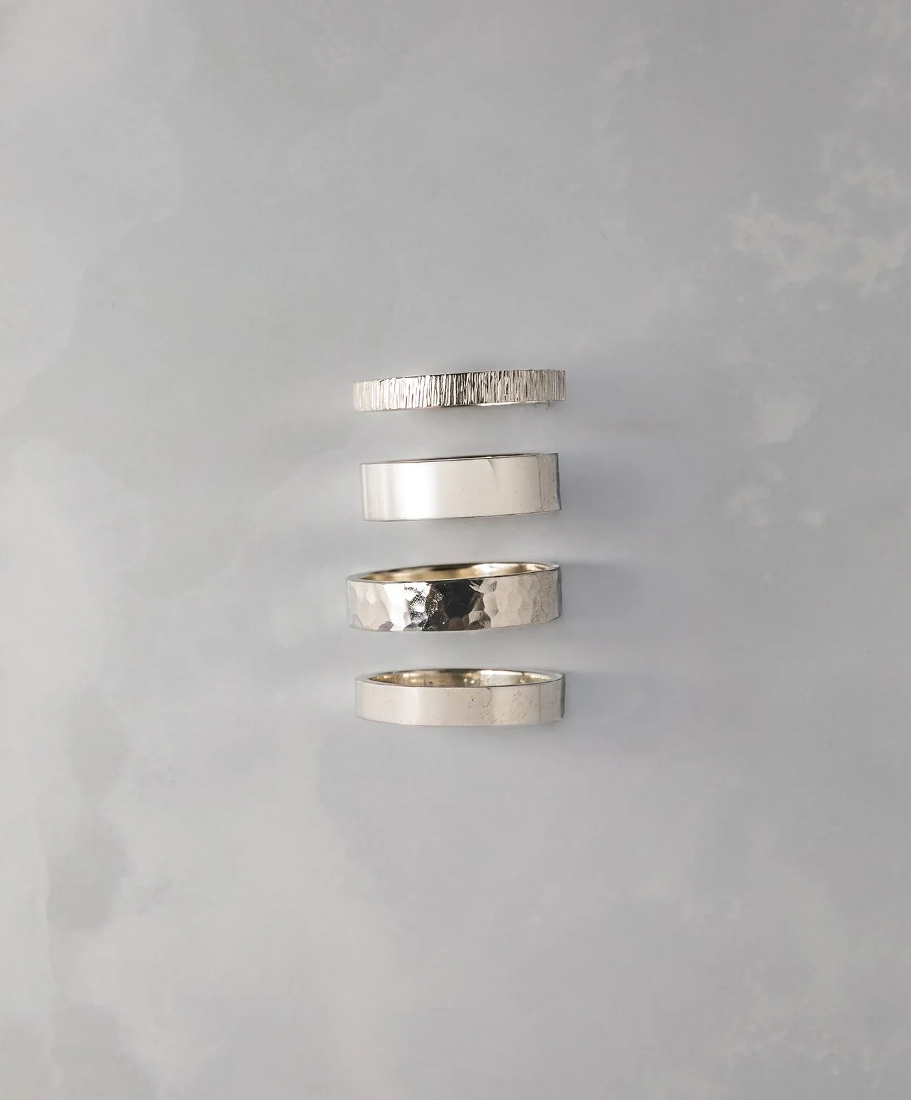 Vijf sterling zilveren ringen met gehamerde structuur in verschillende breedtes.