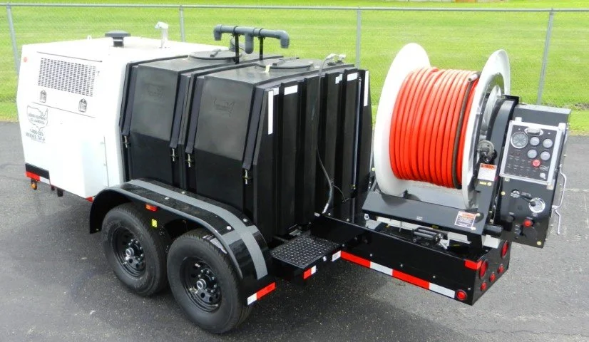 A yellow Putzmeister concrete pump trailer parked outdoors, showing its engine and machinery components with two tires visible.