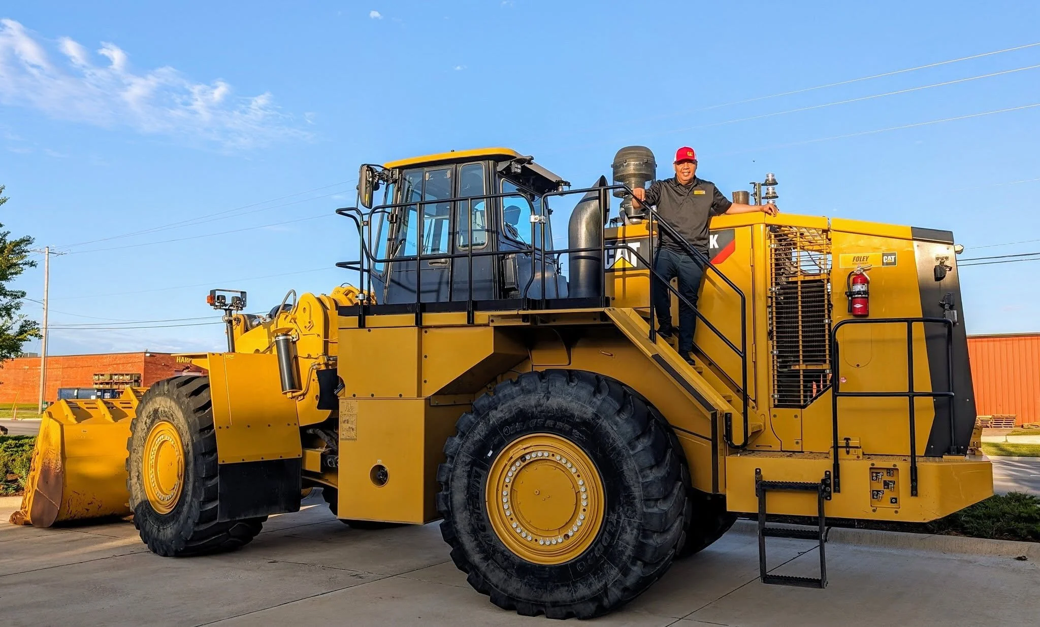 Person in black shirt standing and smiling on heavy equipment