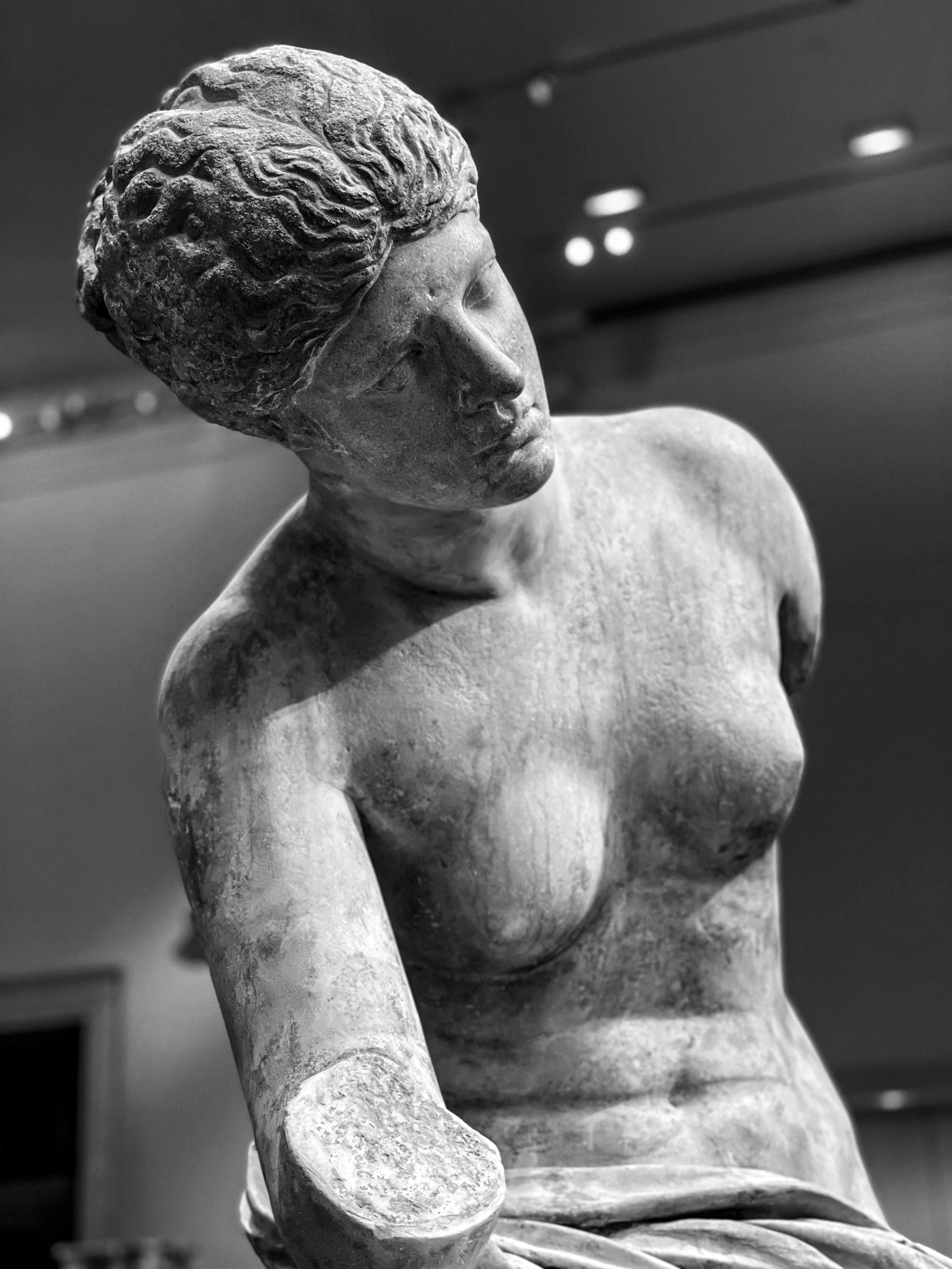 Black-and-white photograph of an ancient Greco-Roman bust displayed at the Metropolitan Museum of Art