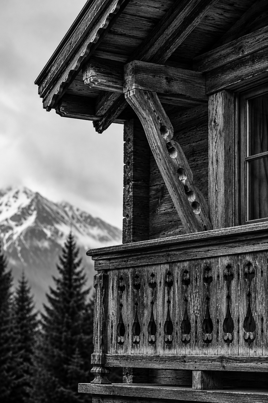 Black-and-white photograph of an Alpine chalet beneath snow-covered mountains