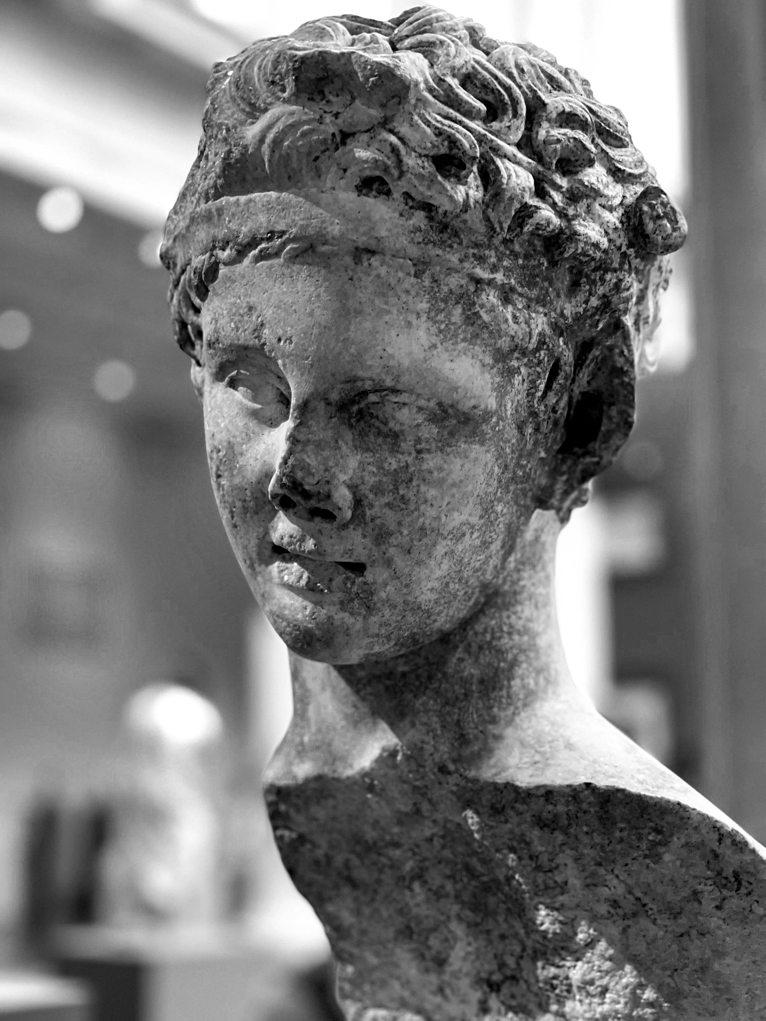 Black-and-white photograph of an ancient Greco-Roman bust in profile displayed at the Metropolitan Museum of Art
