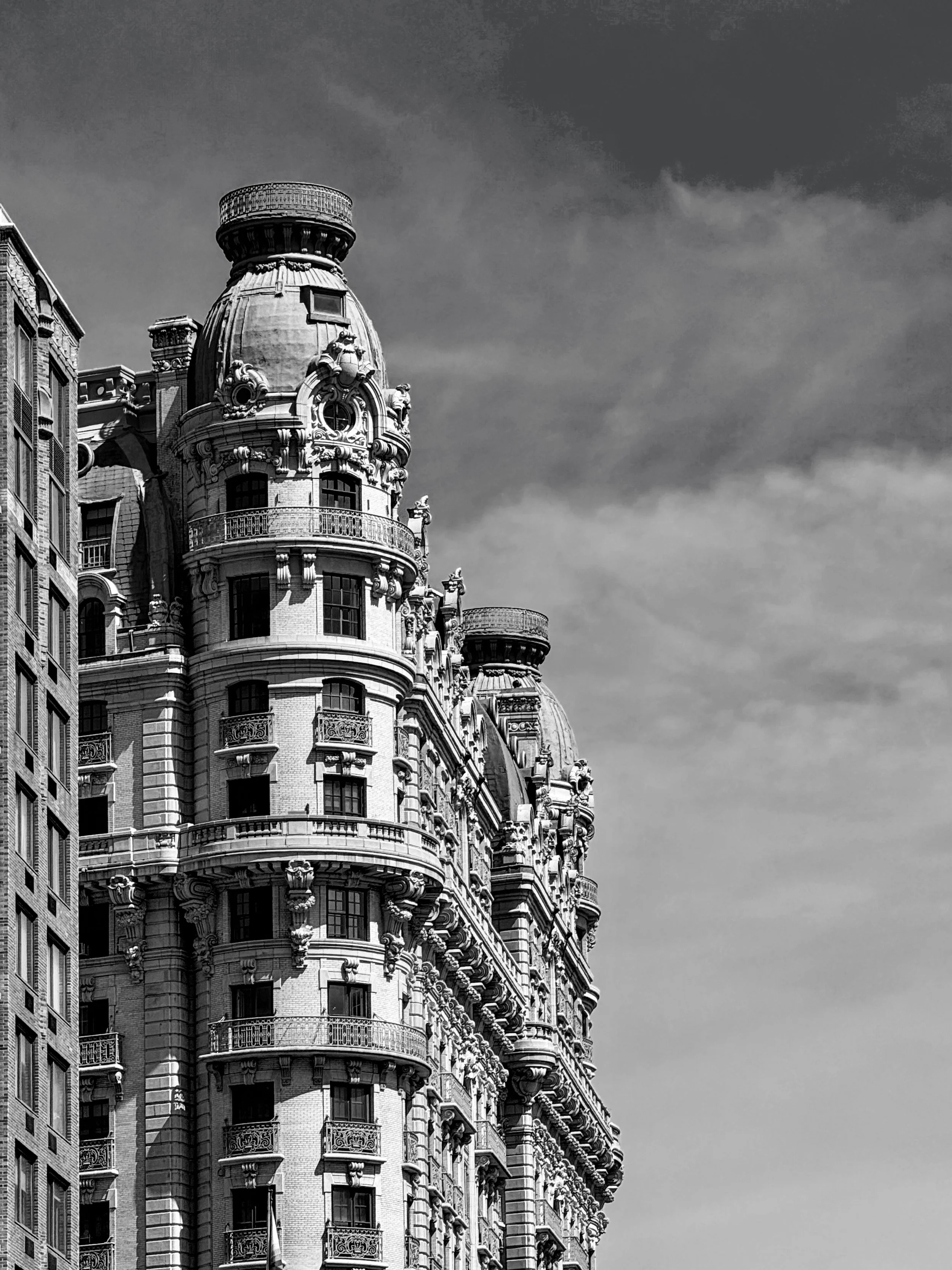 Black-and-white photograph of an ornate prewar building on Manhattan's Upper West Side against a cloudy sky