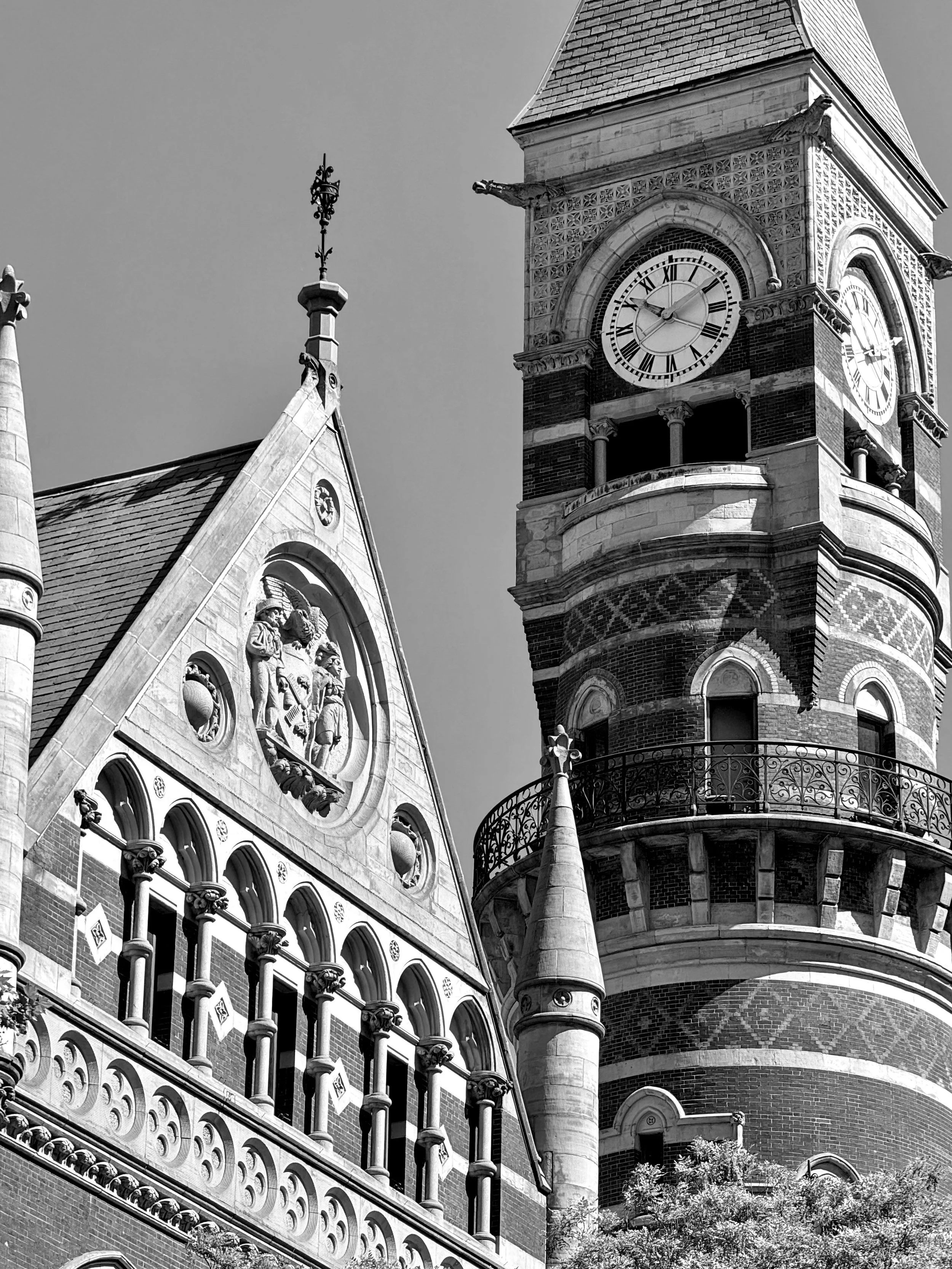Black-and-white photograph looking up at the ornate roofline and clock tower of Jefferson Market Library in Manhattan's West Village