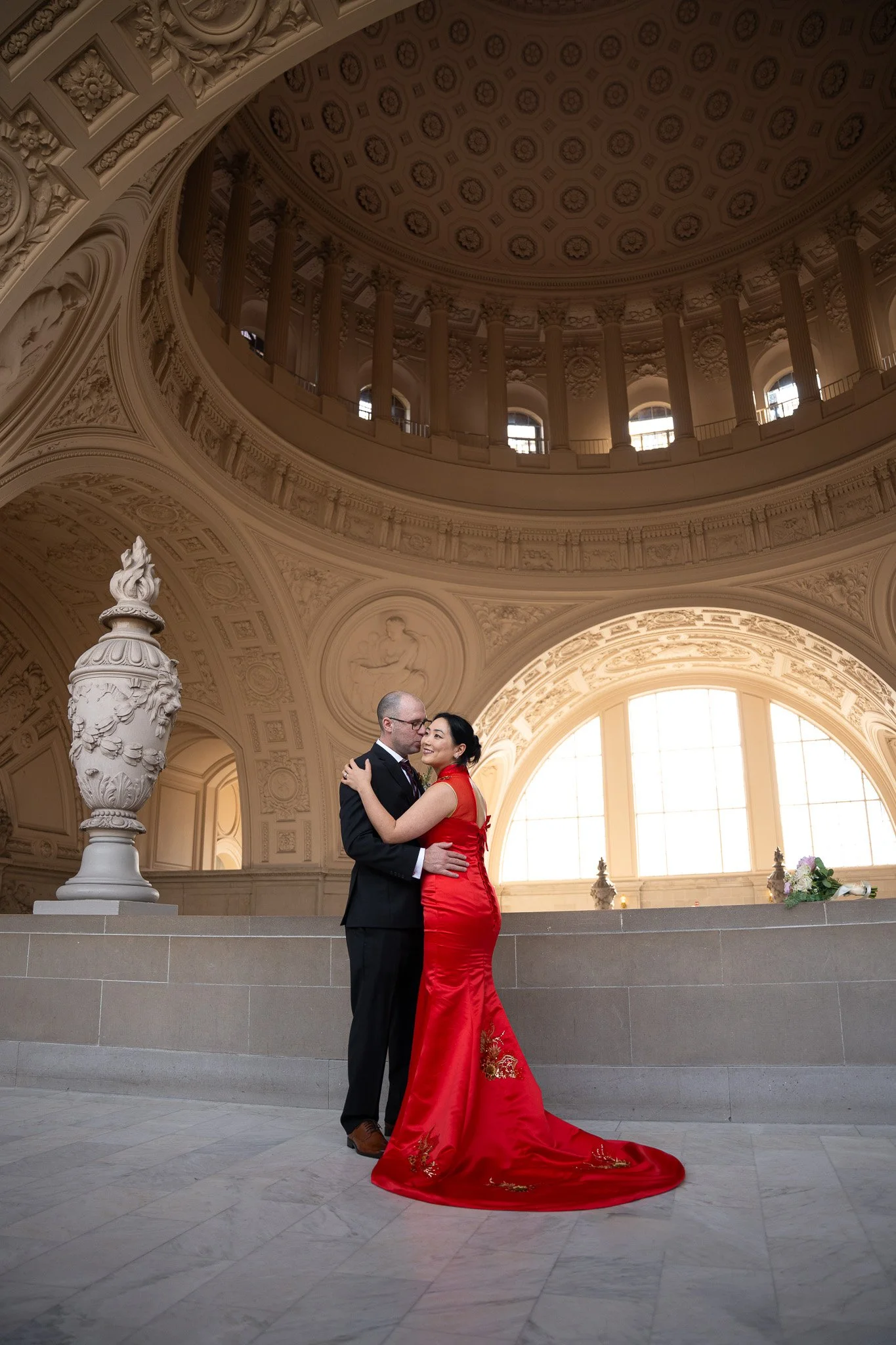SF City Hall wedding photographer — bride and groom kissing inside San Francisco City Hall