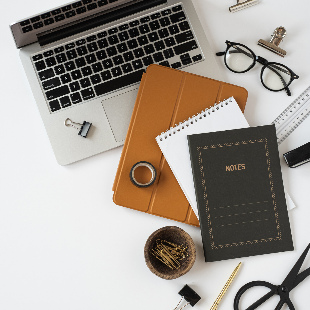 Notebooks, pens, iPad and laptop for digital project management