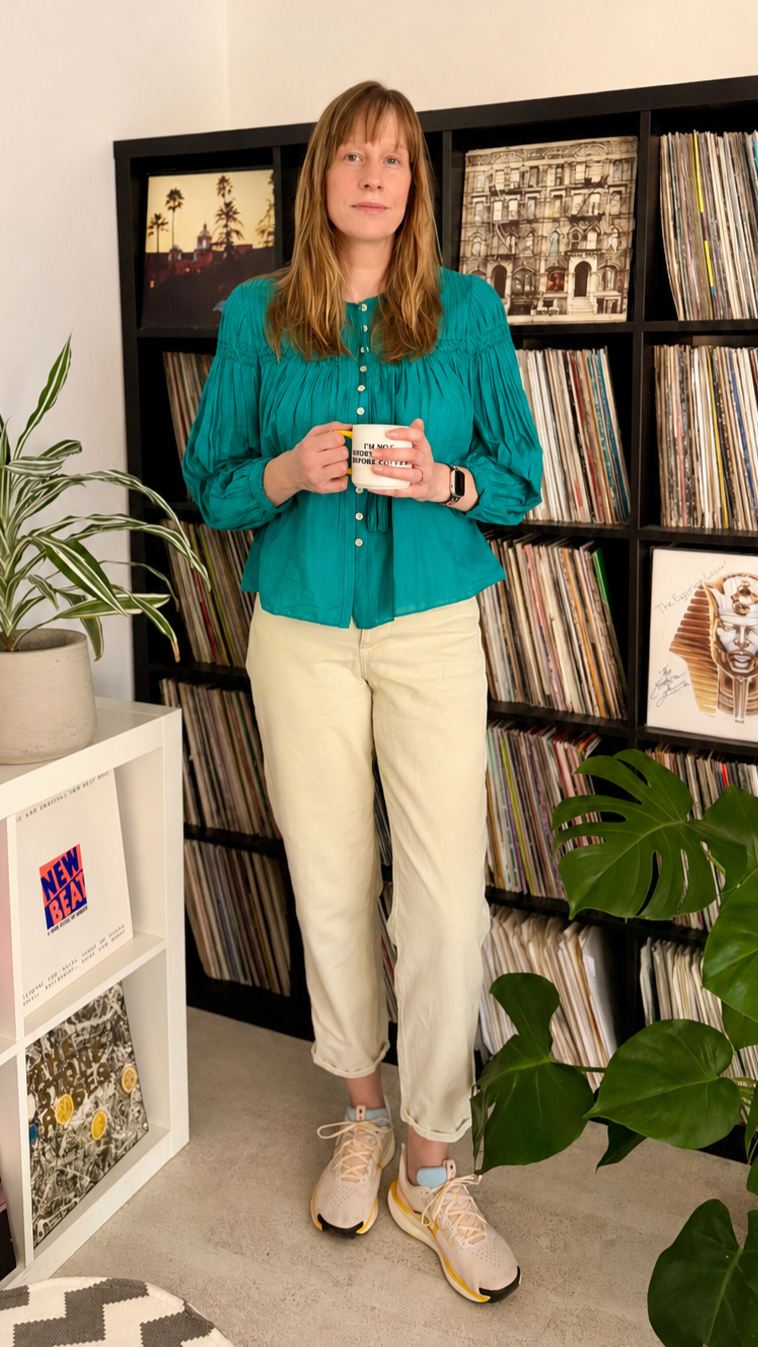 vicki driver stands in front of vinyl record shelves