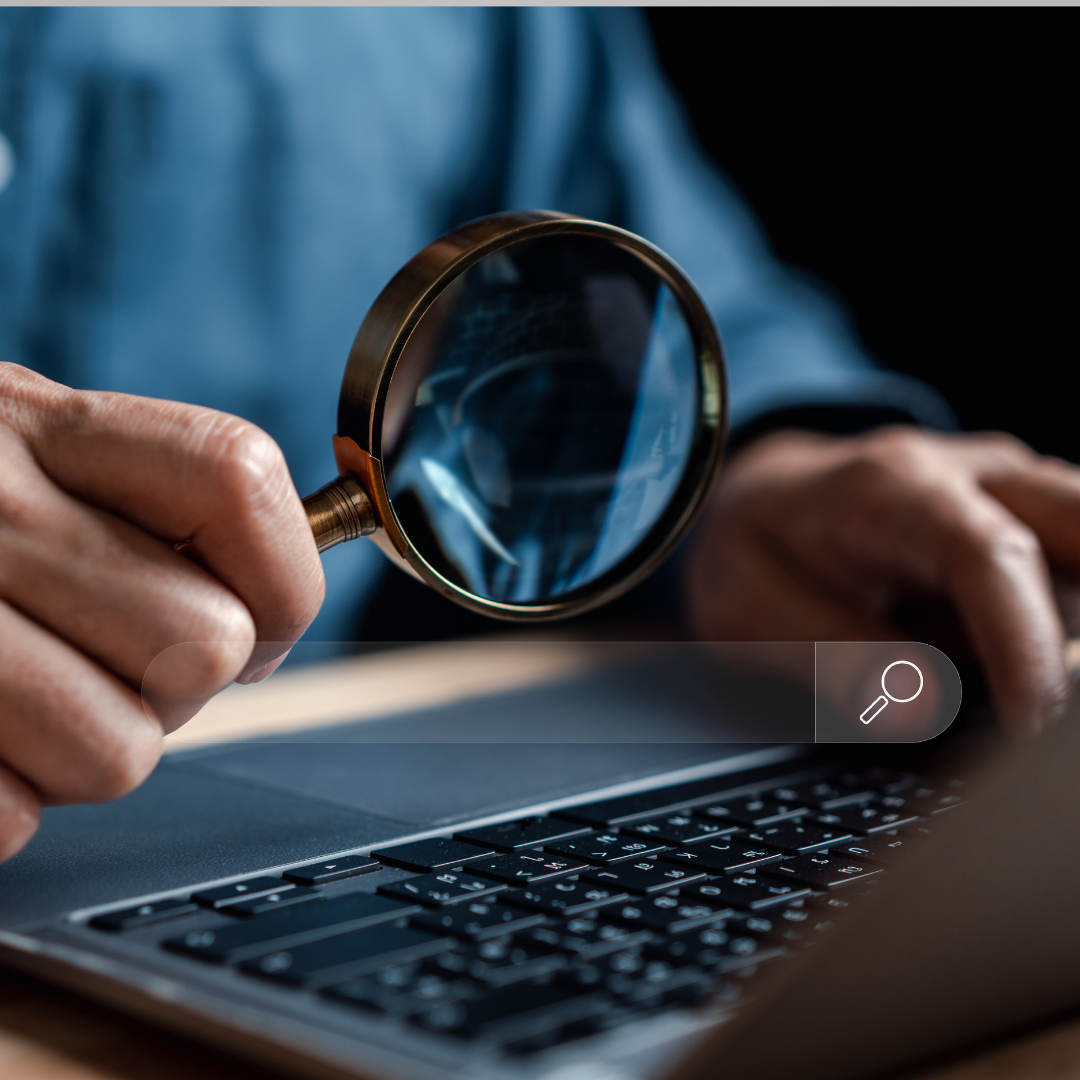 A magnifying glass over a laptop to signify SEO strategy