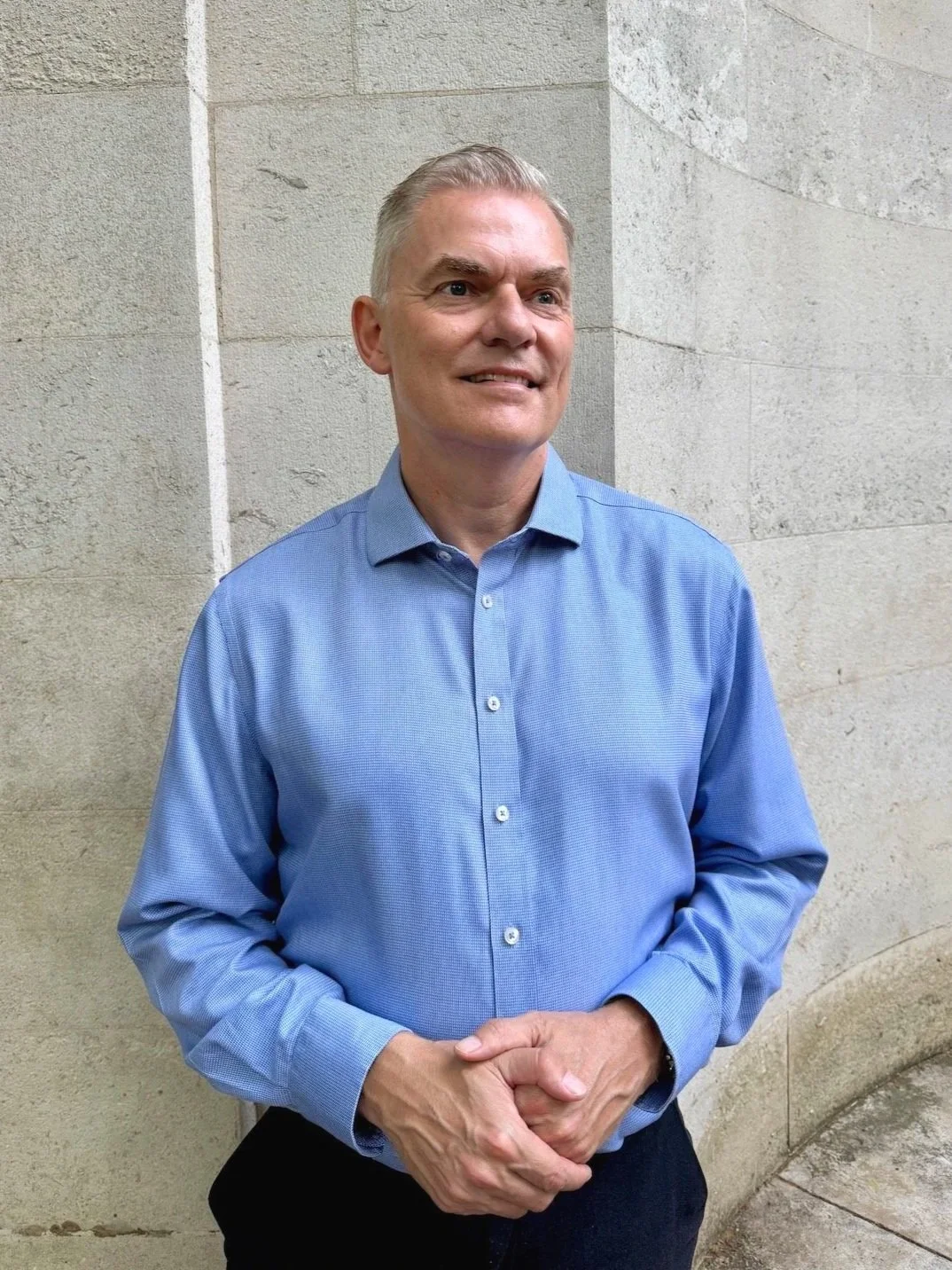 Jakob Holm standing against a wall and smiling