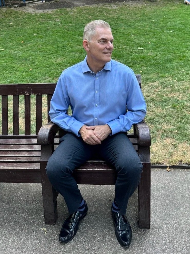 Jakob Holm sitting on a bench and looking into the distance