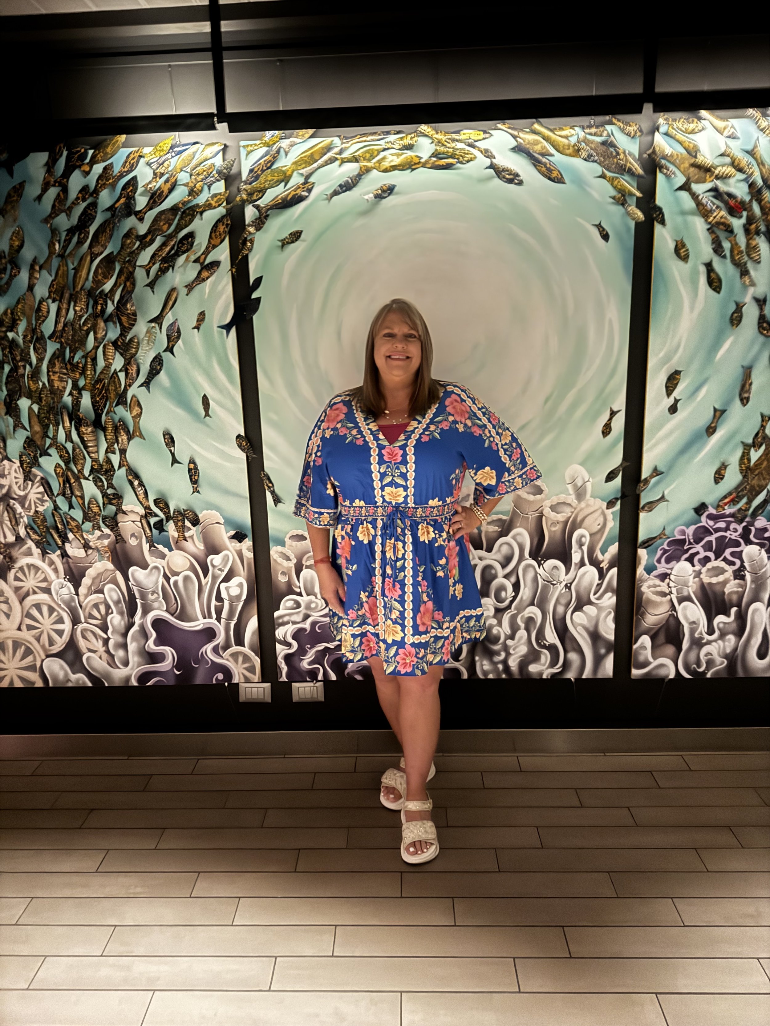 Misti Freeman enjoying a colorful ocean-inspired art display while traveling.