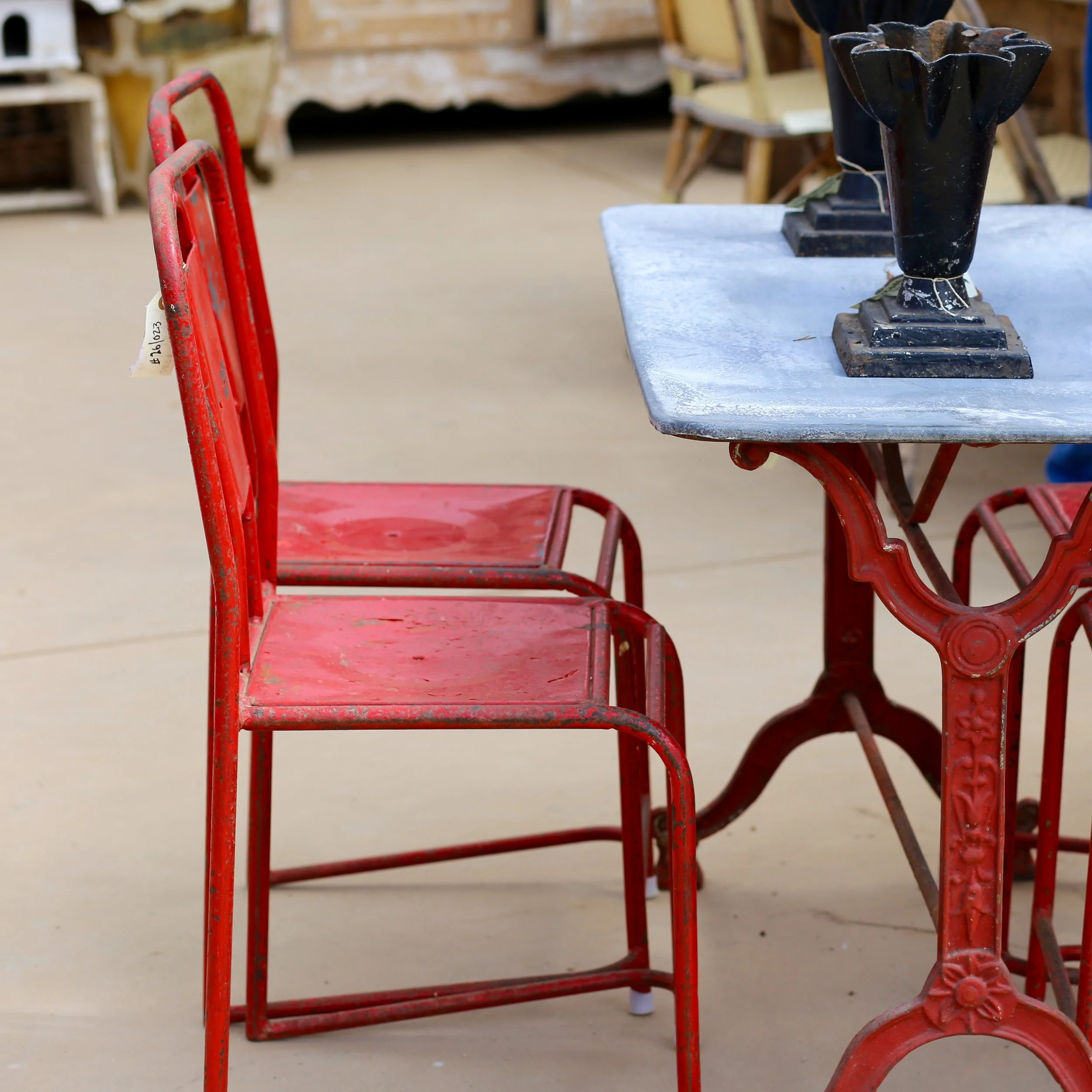 Vintage black and red metal carts and a black vase on a table in an antique store or showroom.