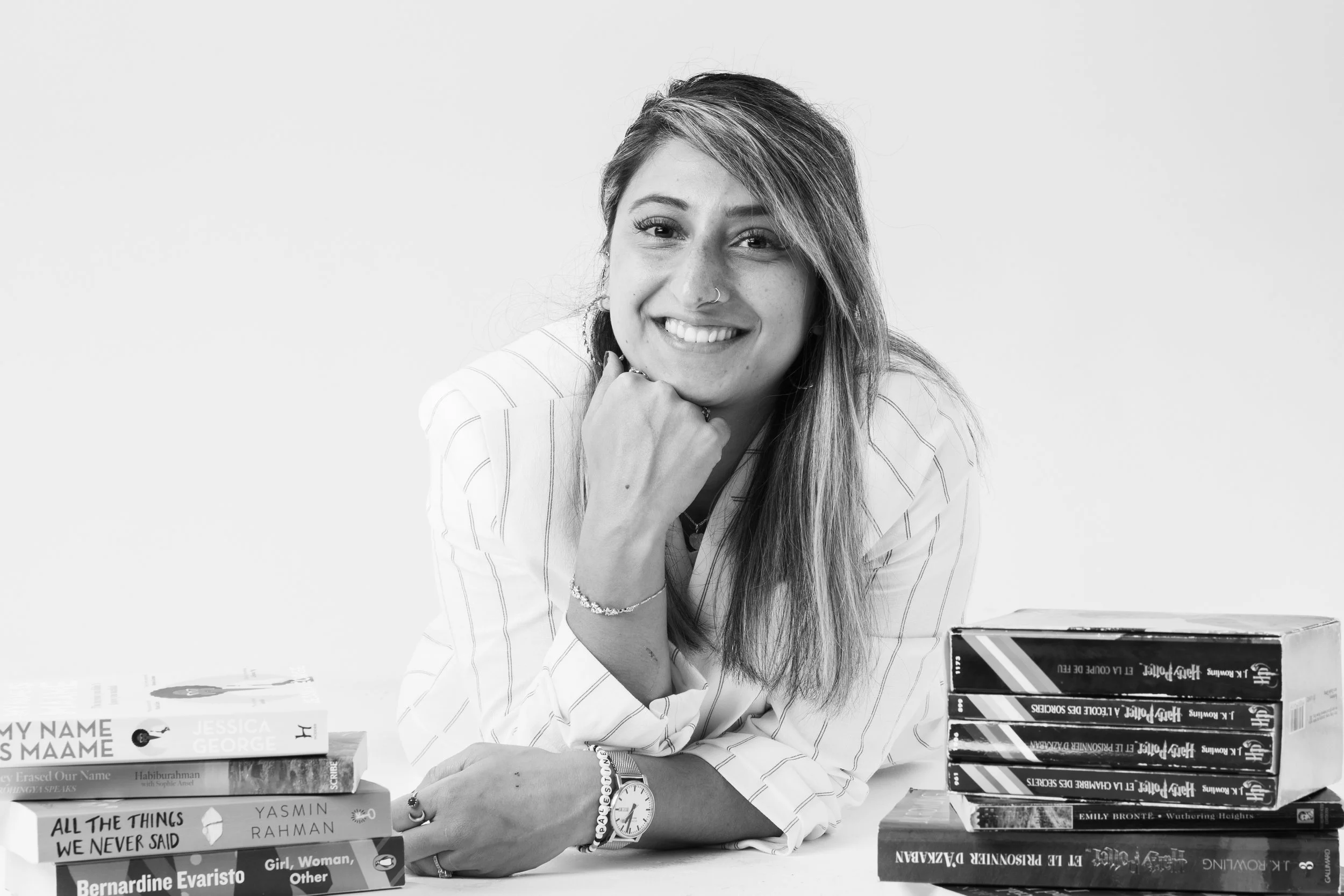 Aiysha, founder of Ignite with Aiysh, with a stack of books — KS3 maths and mindset coaching programme