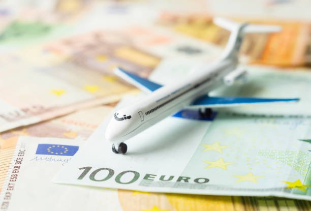 Toy airplane placed on top of 100 euro banknotes.