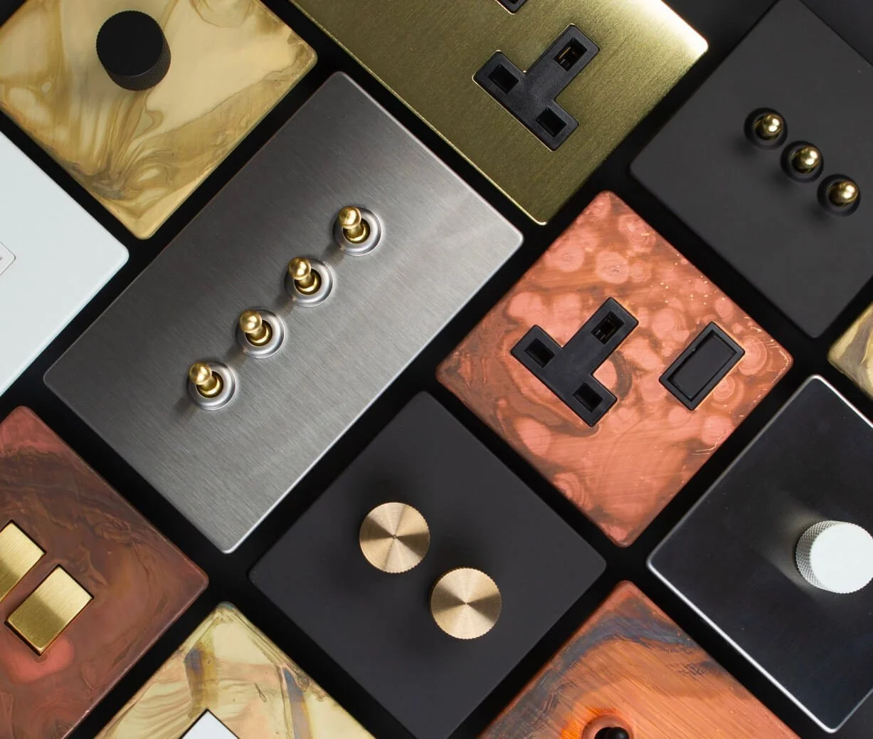 Collection of various decorative power outlets and switches with metallic and marbled designs.