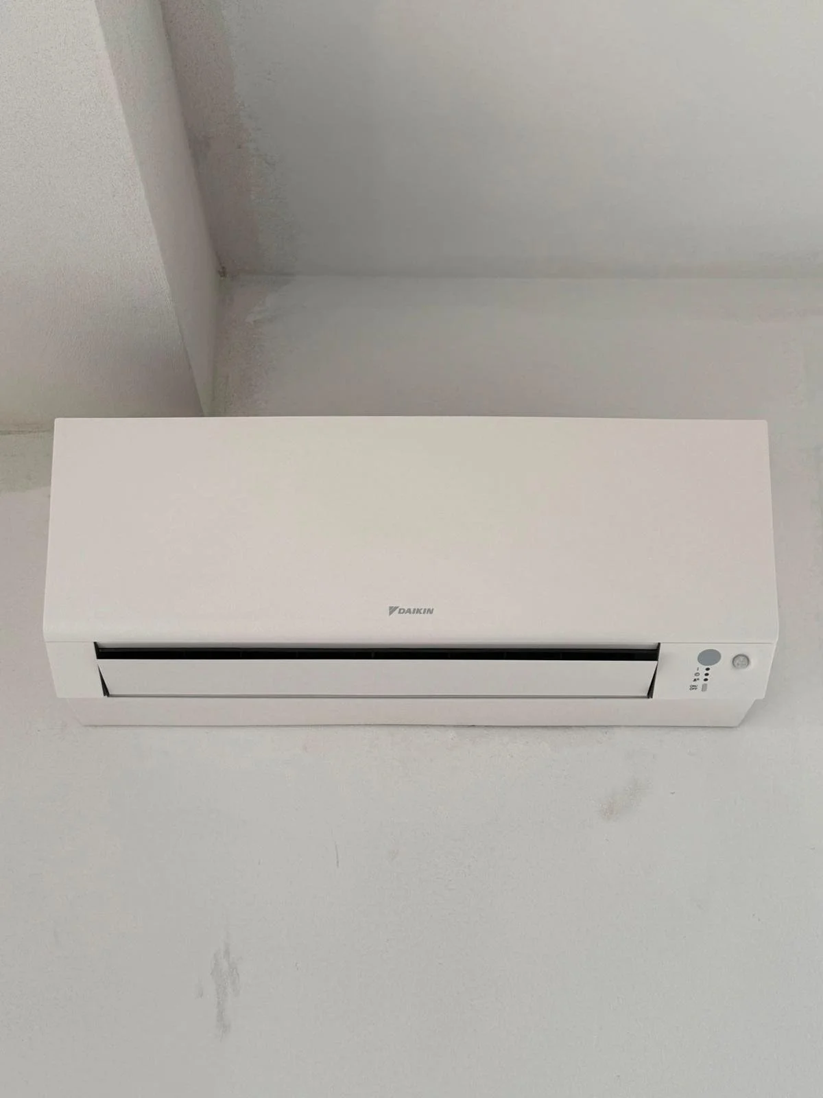 Climatizzatore Daikin bianco installato su una parete bianca