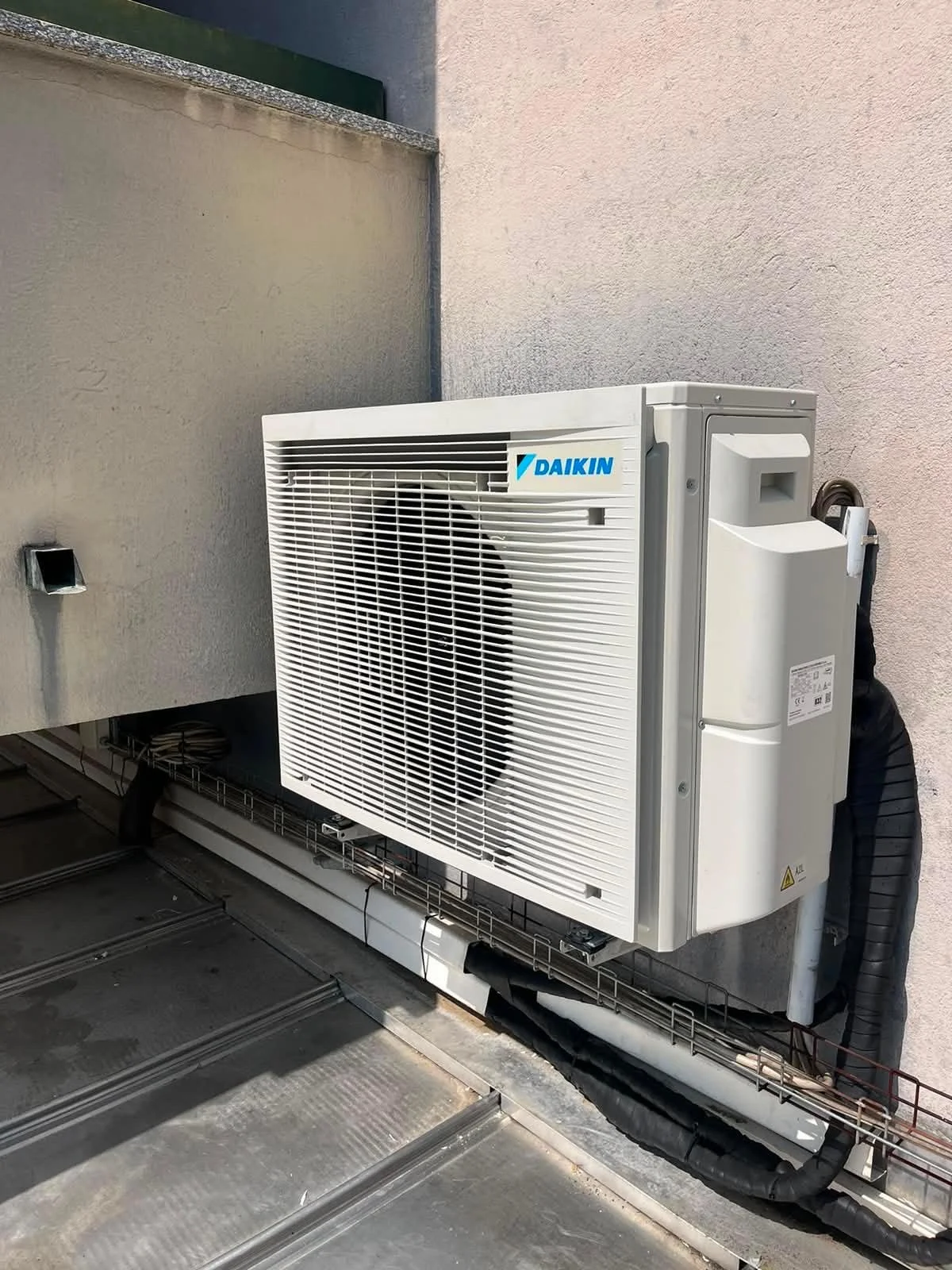 Unità esterna di aria condizionata Daikin installata su un muro di un edificio.