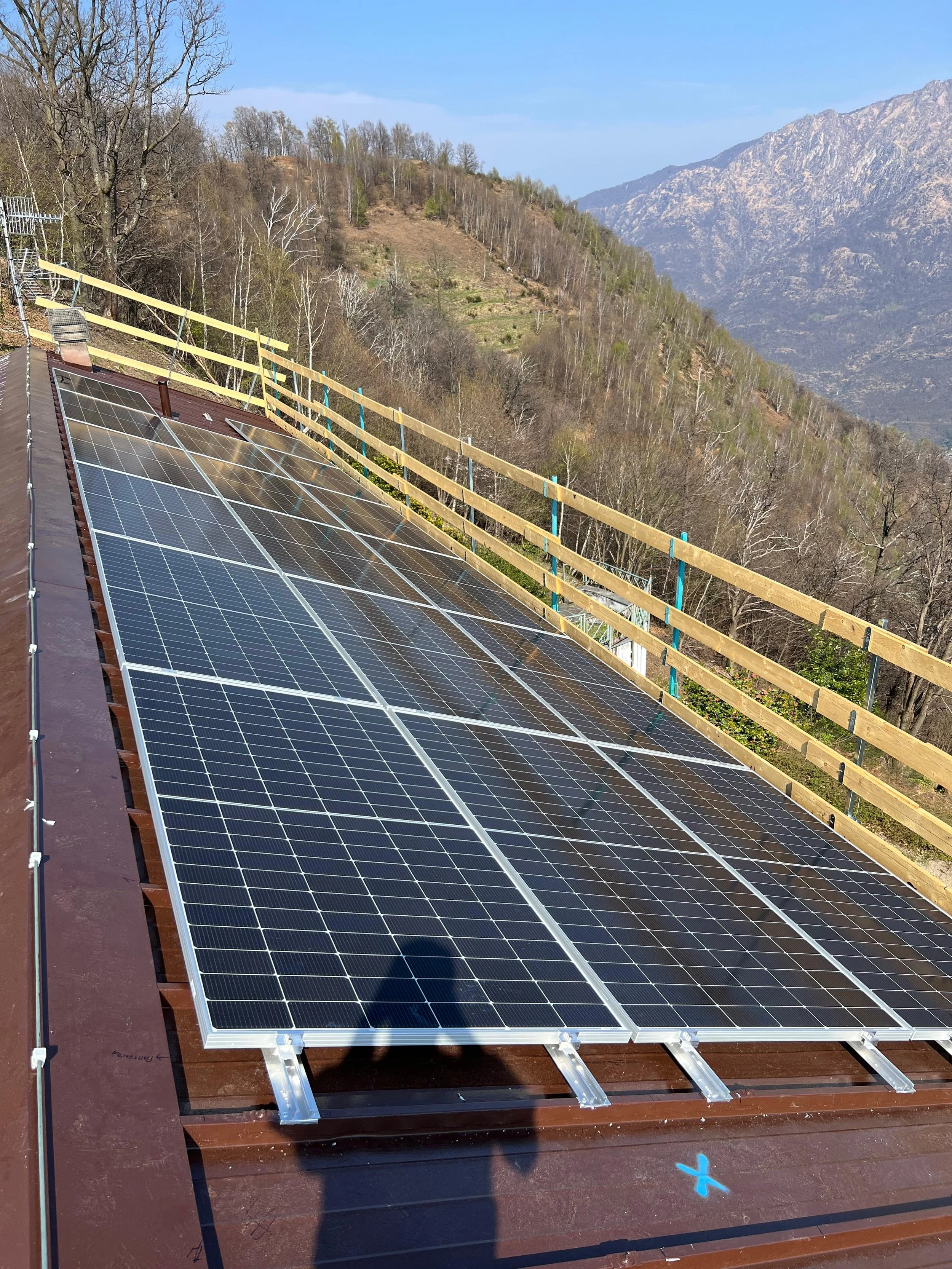 Pannelli solari installati su un tetto con vista su montagne e campagna