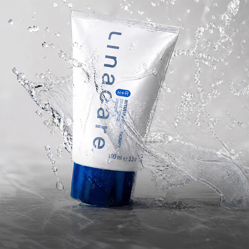 A tube of Lather bath product with water splashing around it.