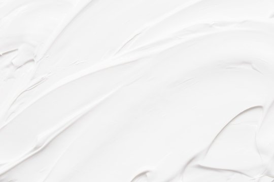 Close-up of a white, textured surface with visible brush strokes or grooves.