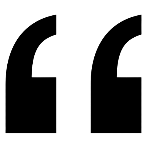 Close-up of black 3D quotation mark symbols on a white background.