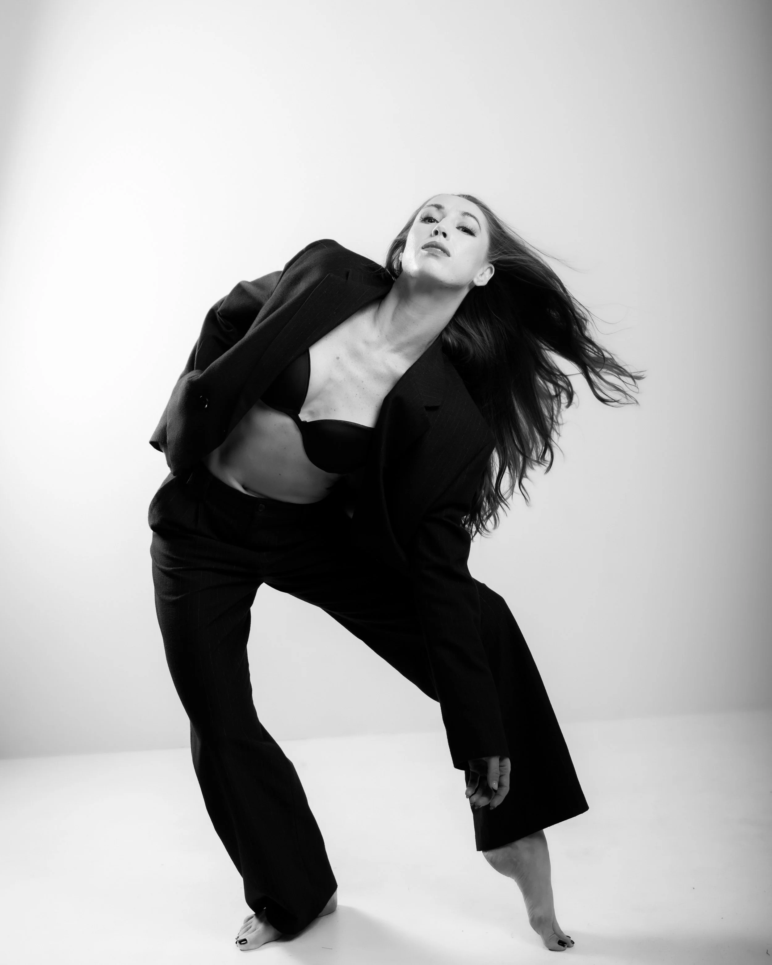 Skylar Schultz performing expressive contemporary movement in a black suit.