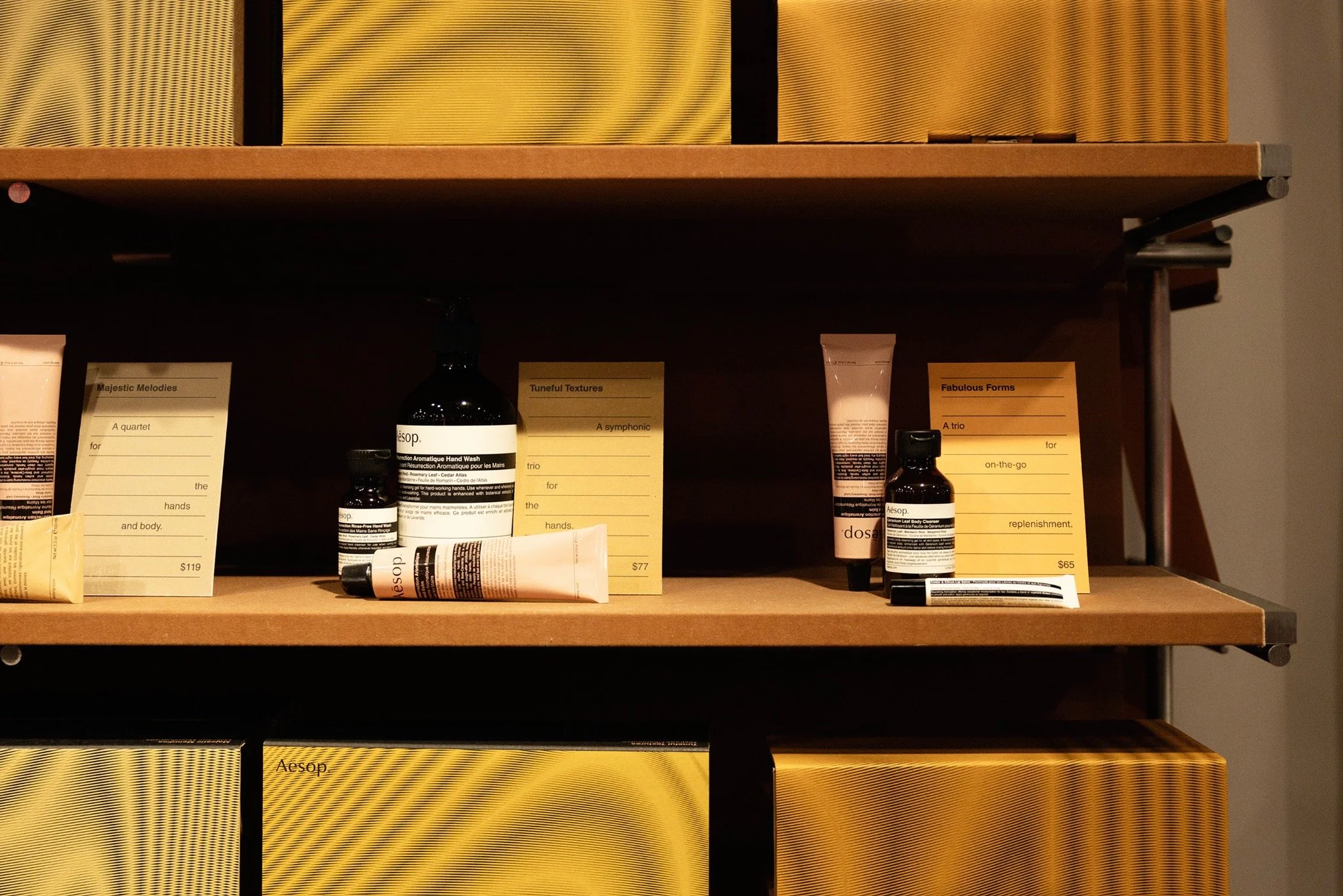 Aesop skincare products and gift sets arranged on wooden shelving inside the NoMad store.