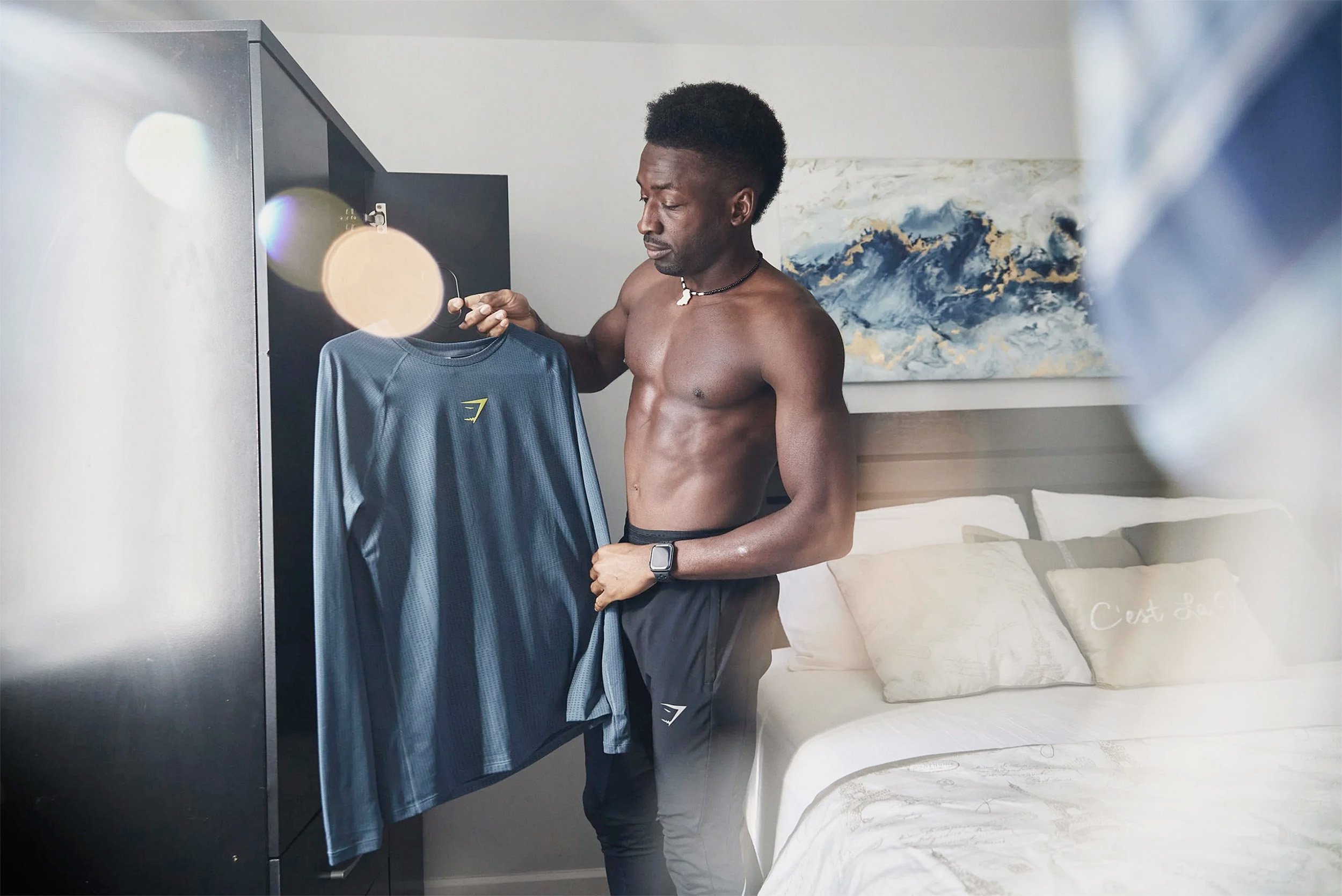 Gymshark athlete holding branded apparel during a lifestyle photography shoot.