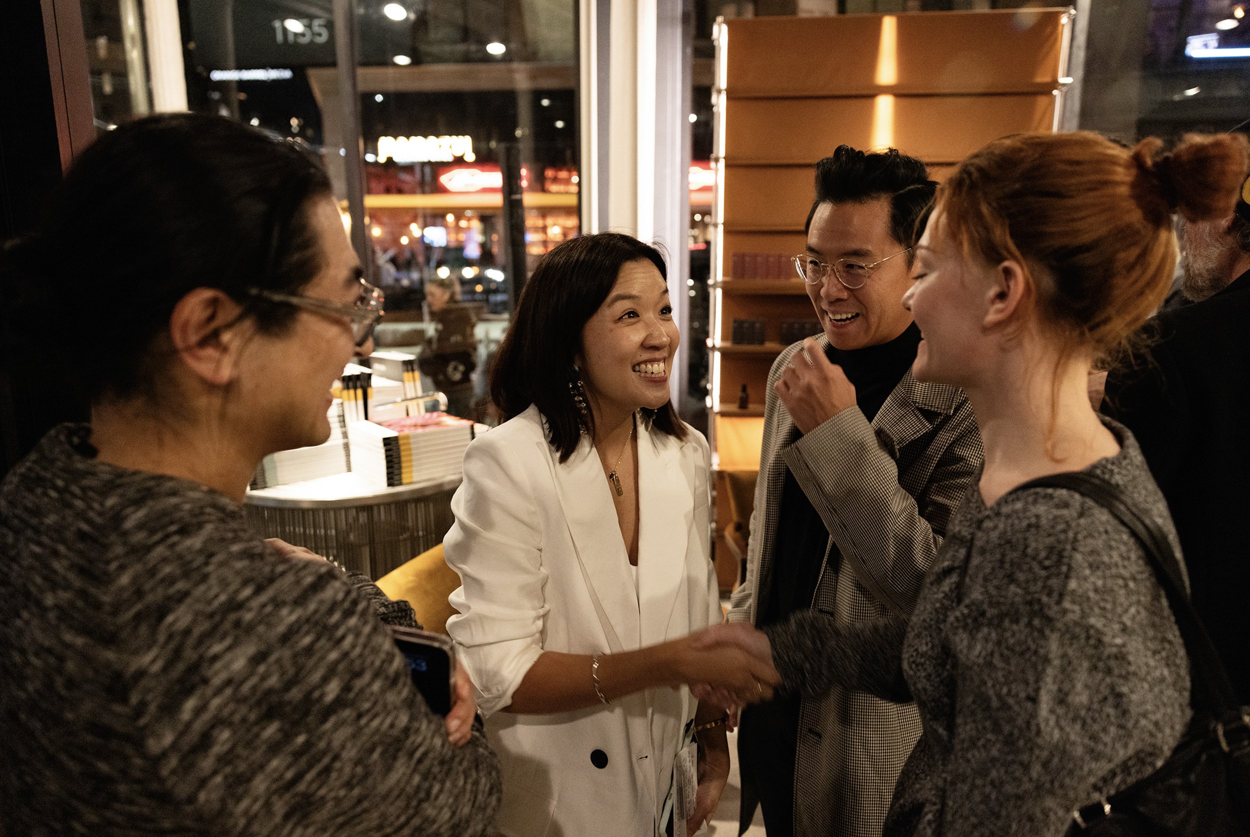 Guests greeting one another at an evening brand event.