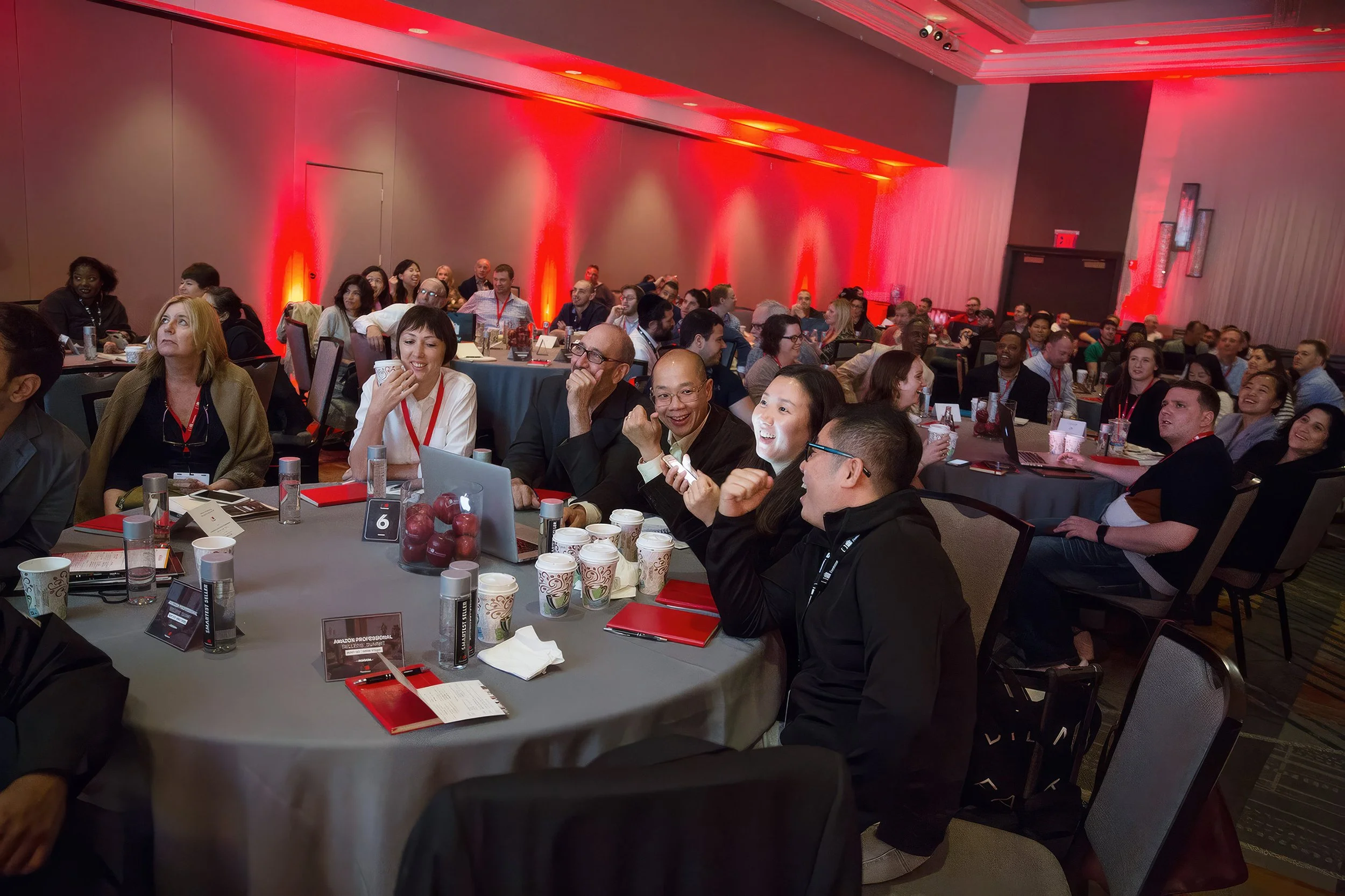 Corporate conference attendees reacting during a live presentation.