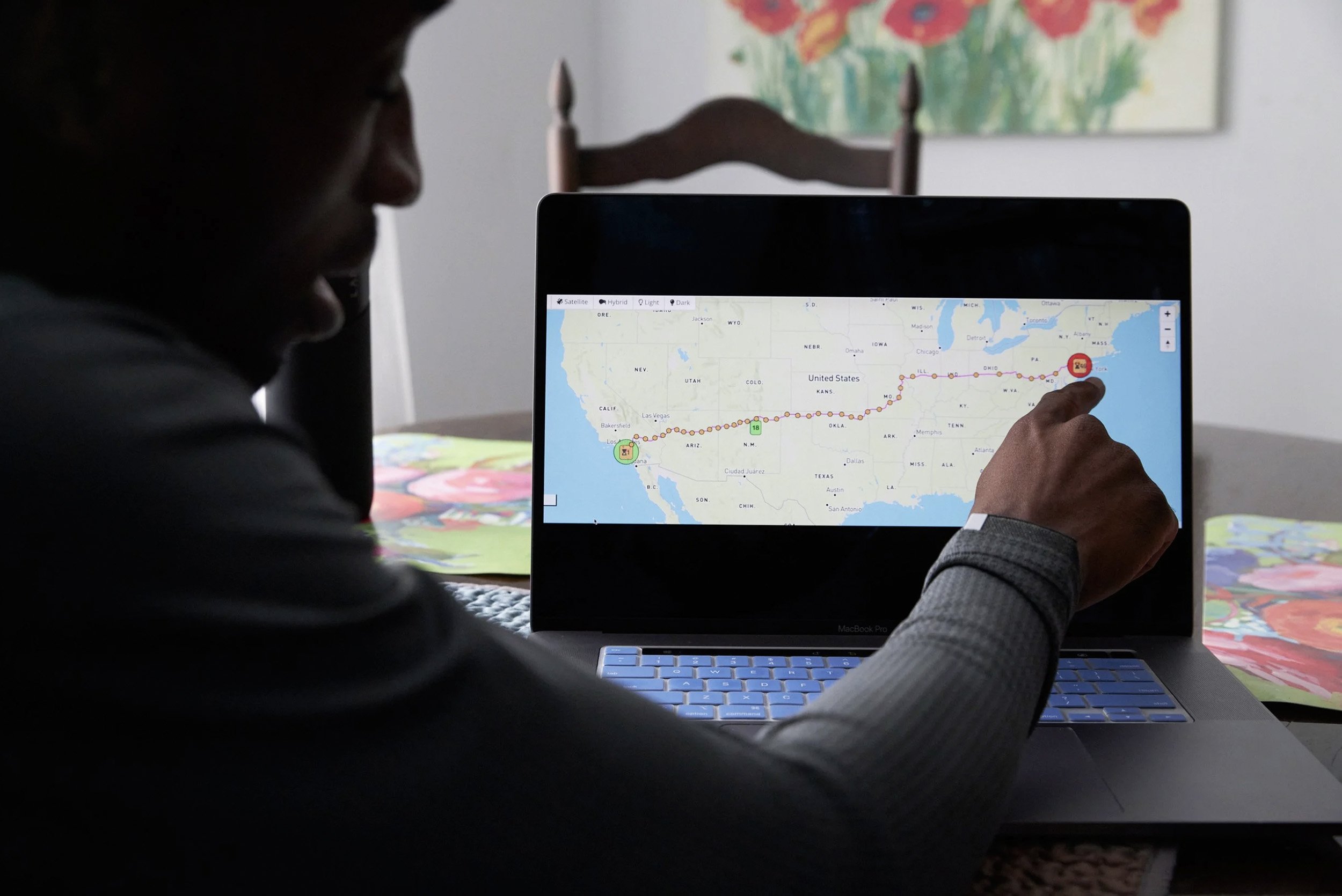 Hellah Sidibe reviewing a cross-country running route on a laptop.