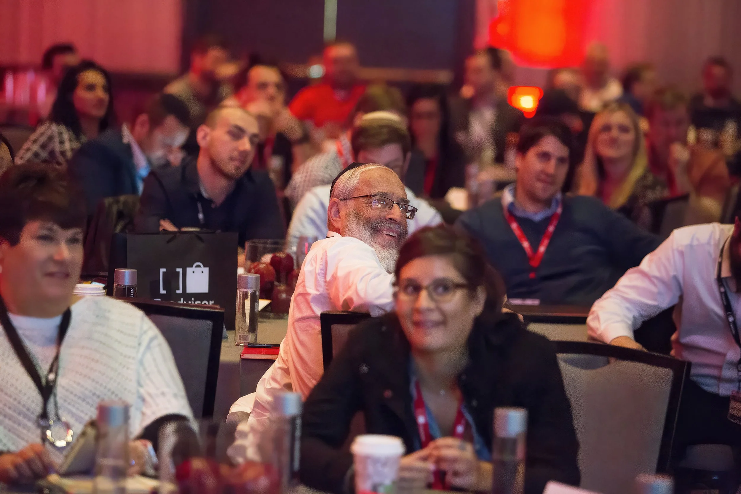 Corporate conference attendees reacting during a live presentation.
