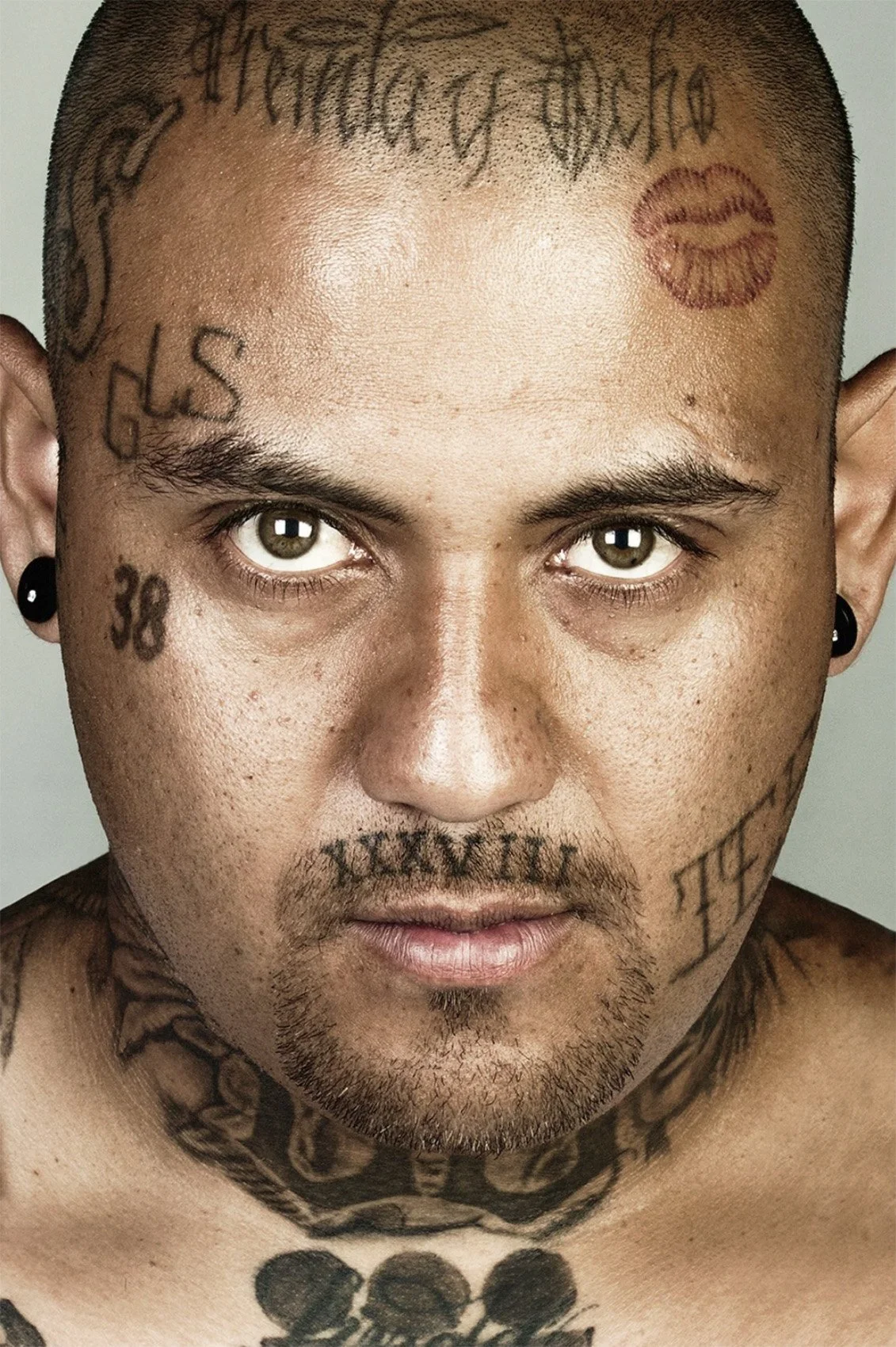 Portrait of Francisco Flores with visible facial and body tattoos.