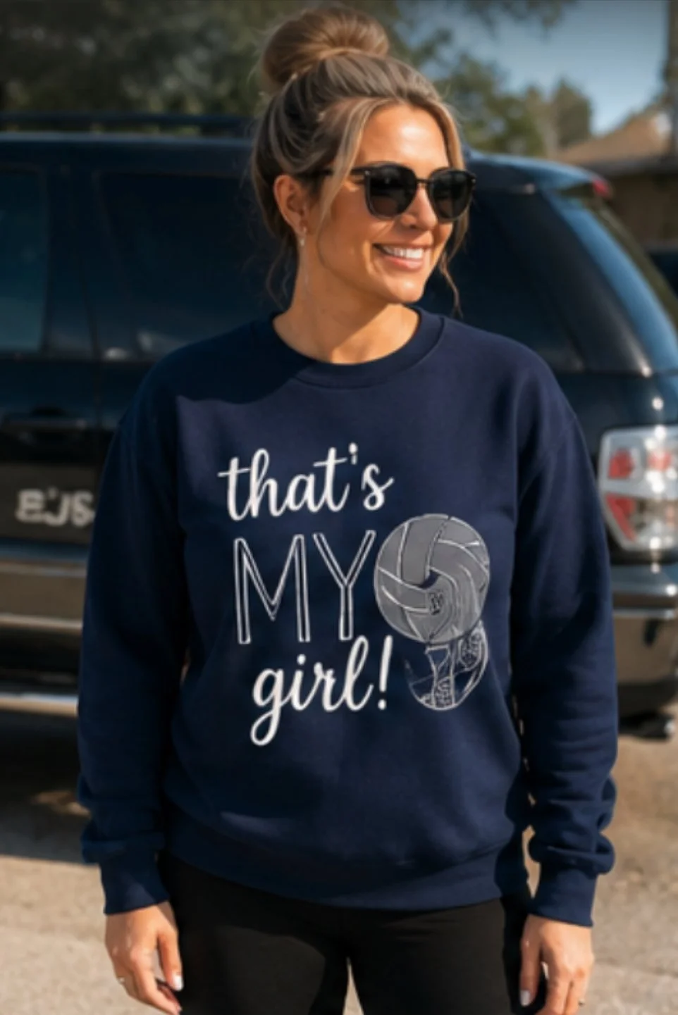 Woman wearing sunglasses and a navy sweatshirt with volleyball graphic and text 'that's MY girl!'